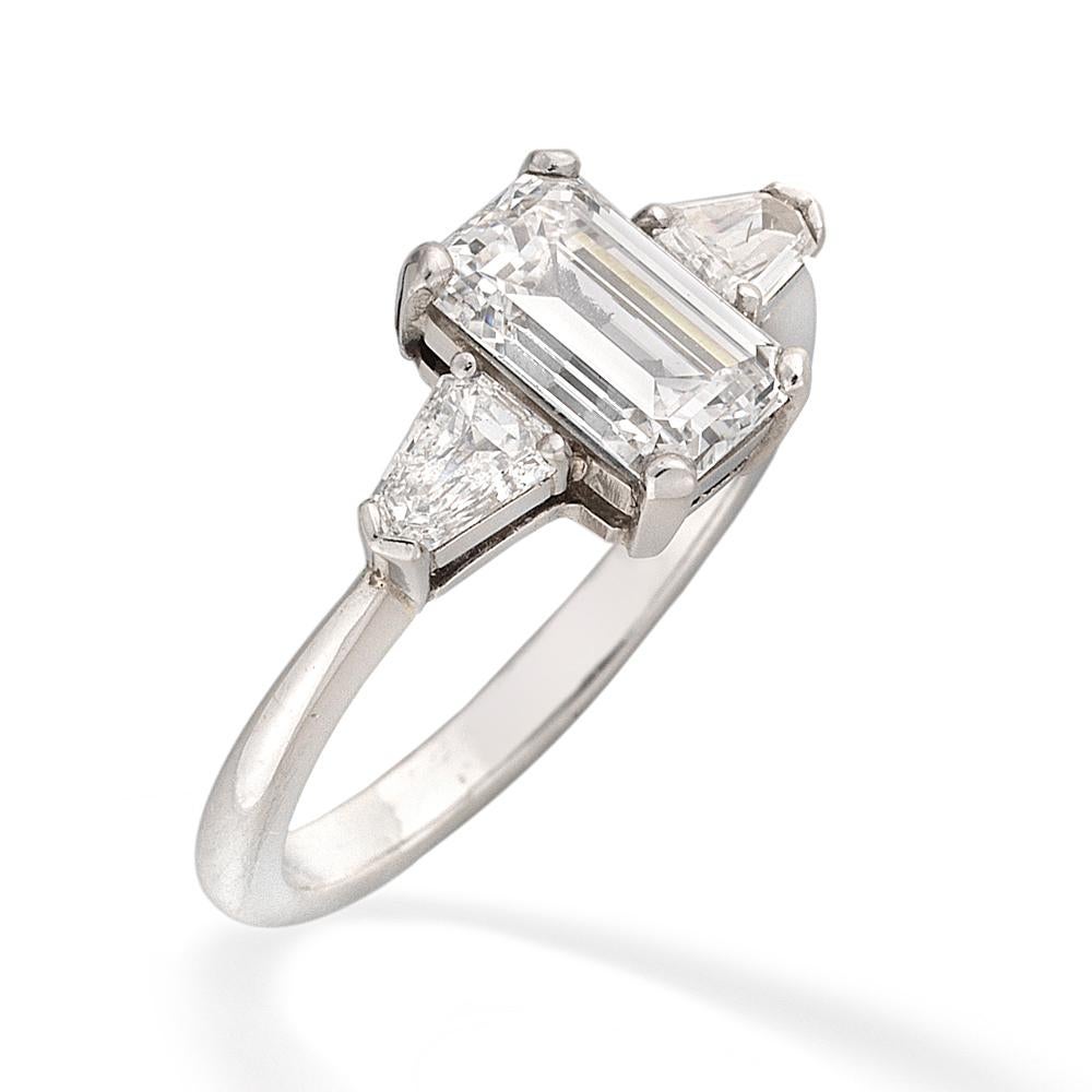A single stone solitaire diamond ring, the emerald-cut diamond weighing 1.47 carats, of F colour, VS1 clarity, GIA certificate, four claw-set to the centre of two tapered baguette-cut diamonds, estimated to weigh a total of 0.50 carats, claw-set to