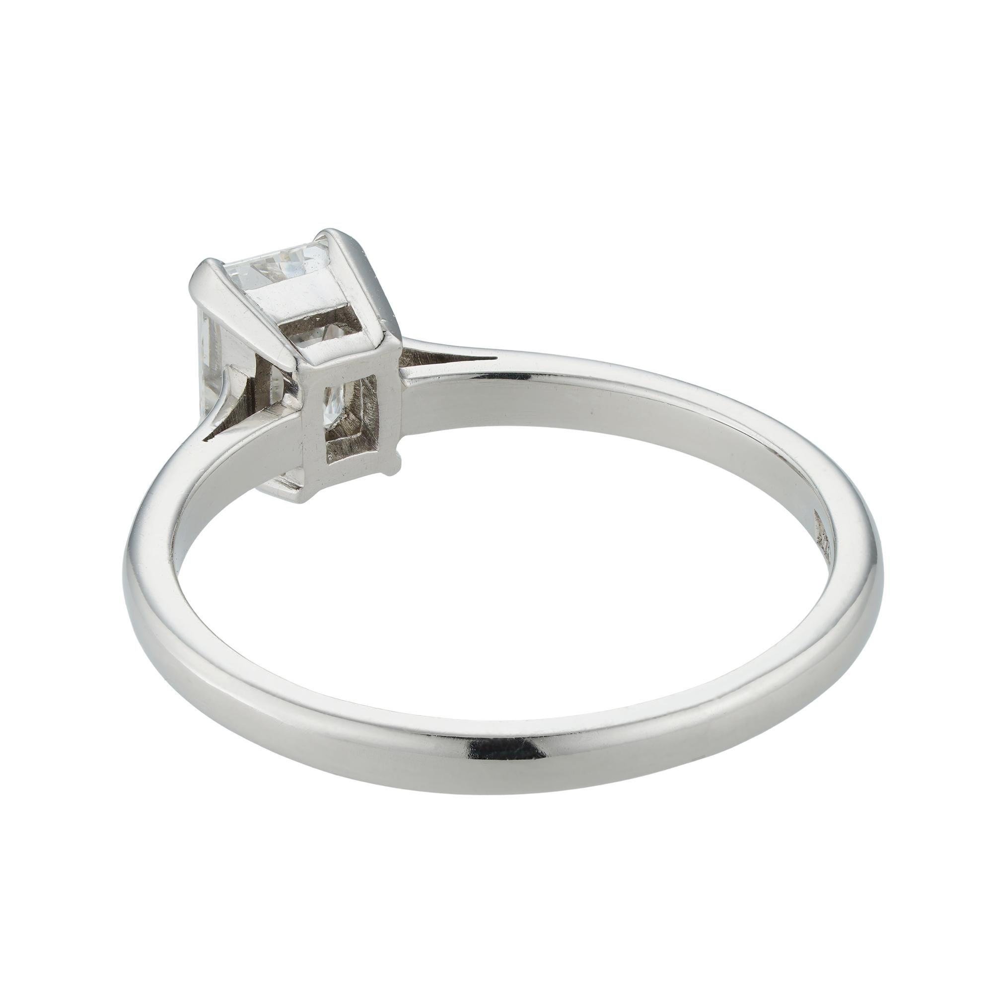 An emerald-cut single stone diamond ring,  weighing 0.74 carats accompanied by Anchor Cert report, stating to be of G colour and SI1 clarity , four claw-set to a platinum mount with D section shank, hallmarked London 2000, with millennium mark and