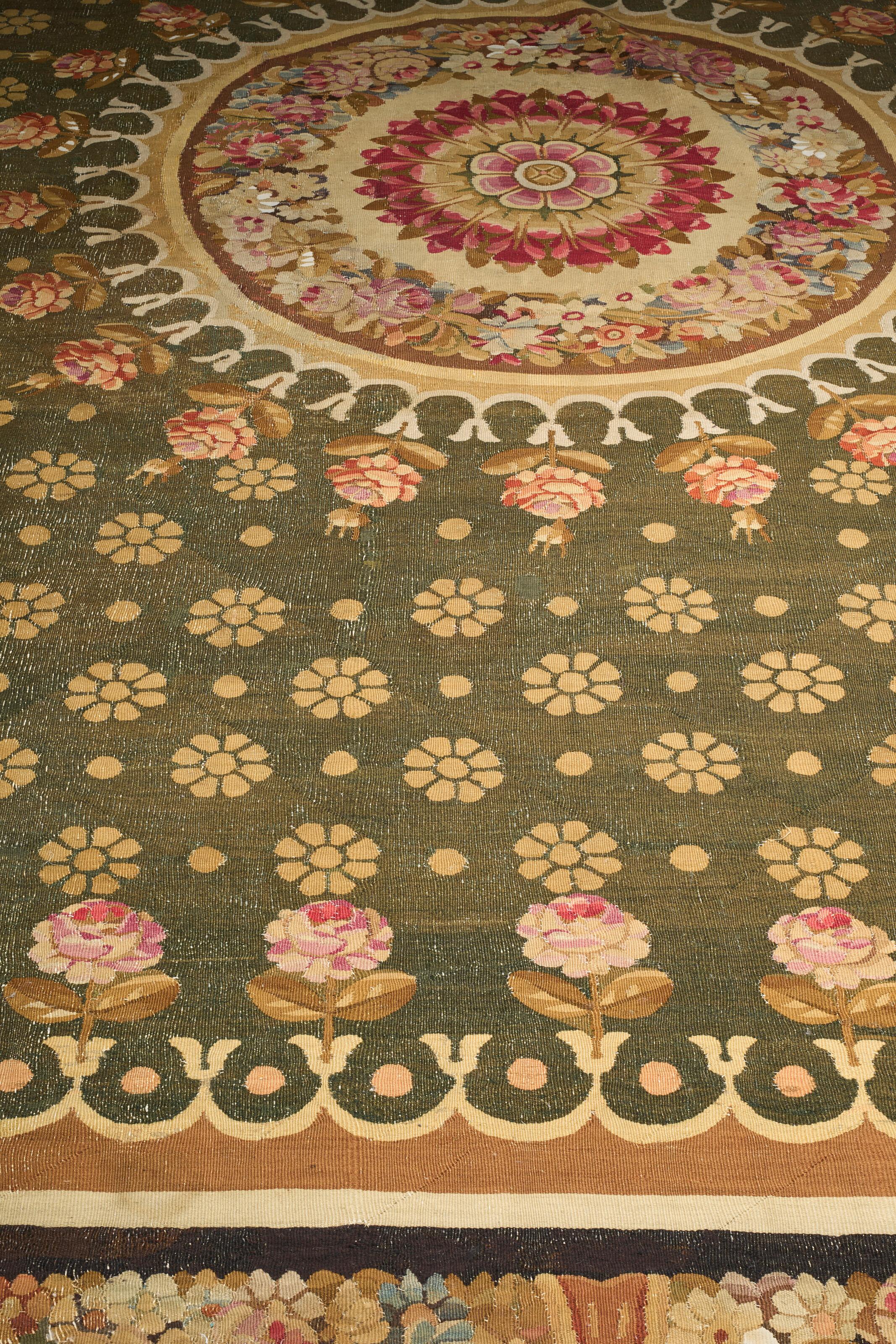 Il campo verde è intessuto di teste di fiori e bouquet agli angoli, il medaglione centrale è intessuto di fiori, all'interno di un bordo fiorito.
16 ft. 11 in. (515 cm.) x 13 ft. 9 in. (419 cm.)