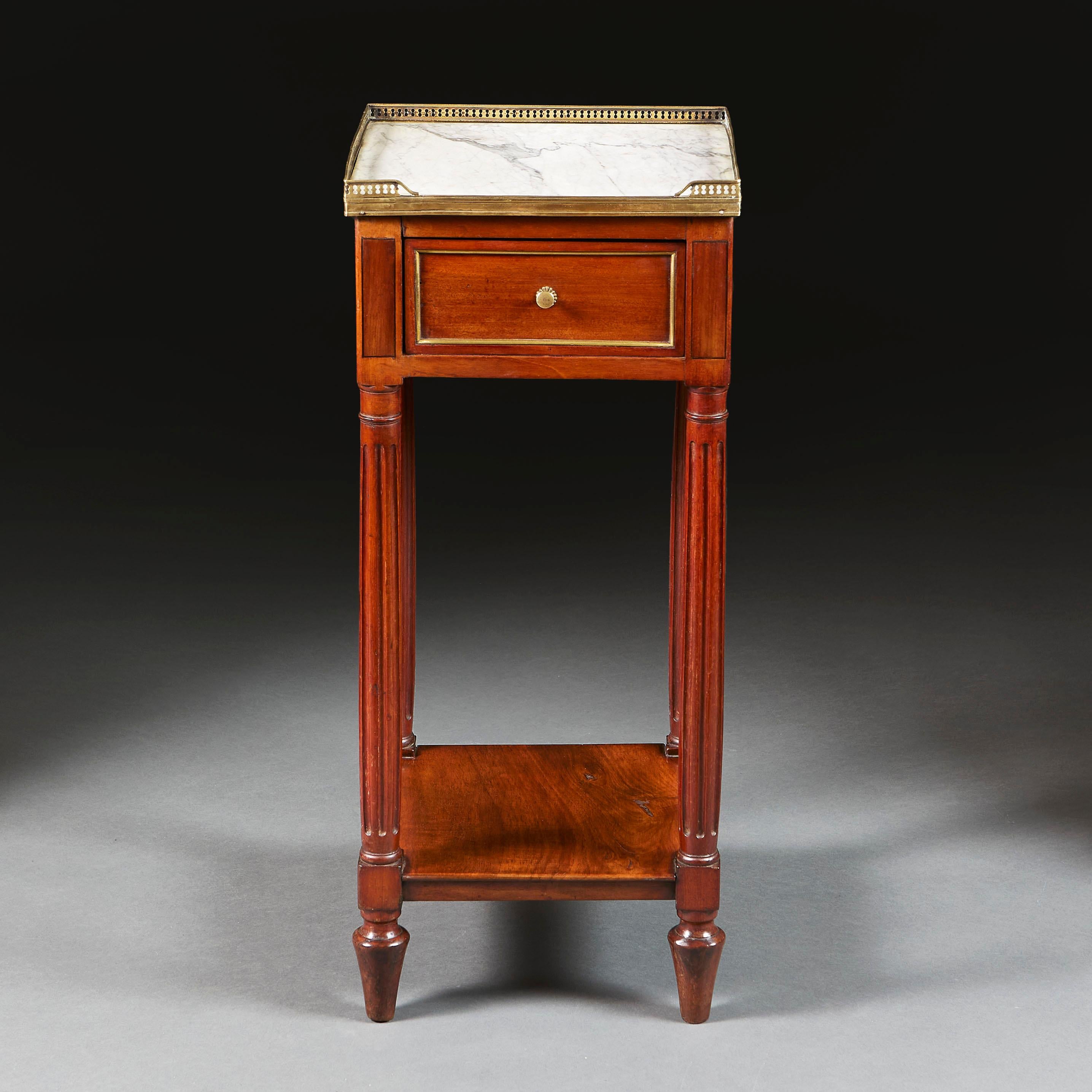 Frankreich, um 1820

Ein Nachttisch aus Mahagoni aus dem frühen neunzehnten Jahrhundert mit einer Schublade im Fries, einer Platte aus weißem Marmor, umgeben von einer Galerie aus Messing, die auf kannelierten, sich verjüngenden Beinen steht.

Höhe