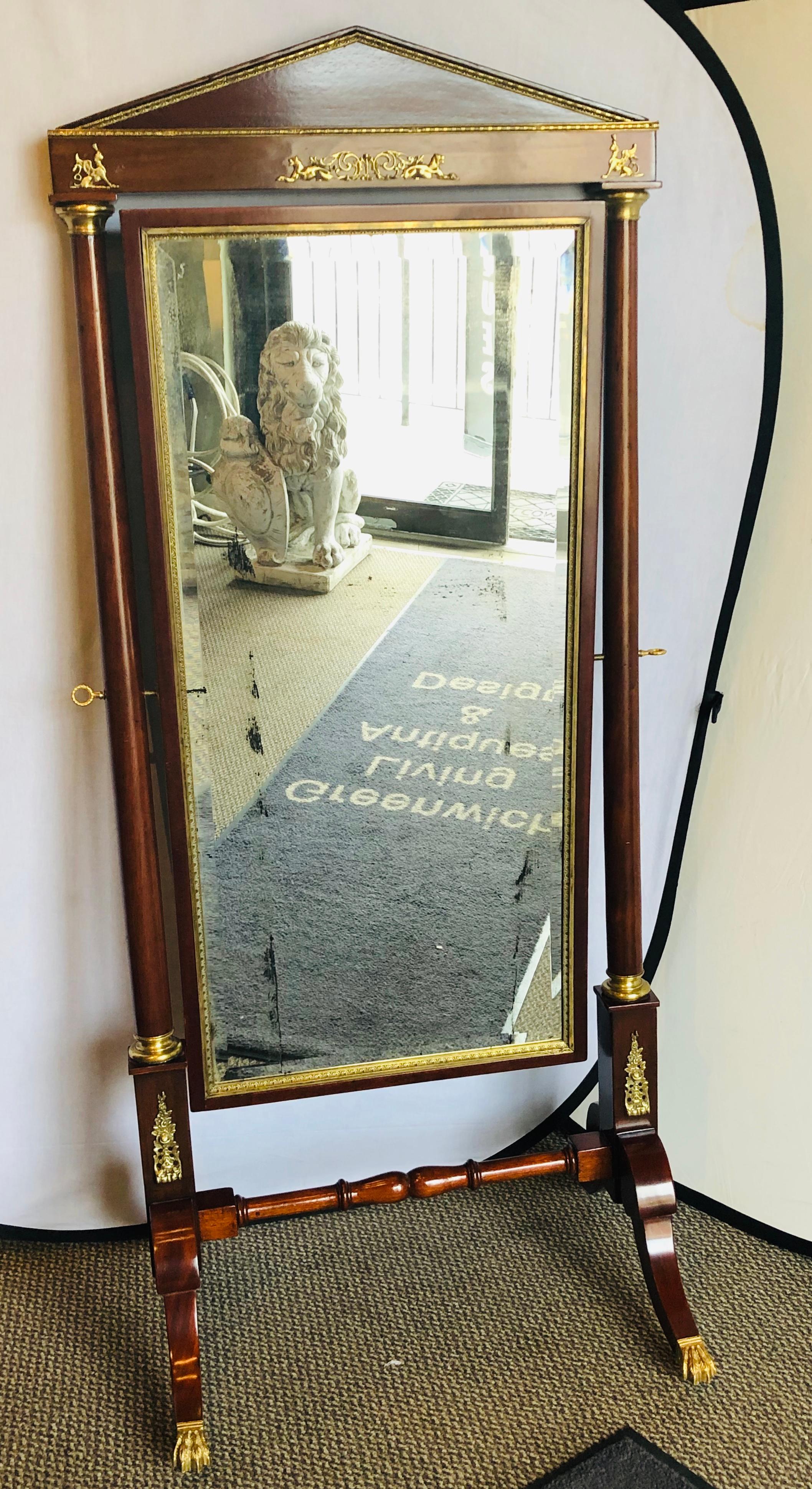 An Empire cheval floor full length mirror with bronze mounts, circa 19th-20th century. This sleek and stylish floor or full length cheval mirror can sit in most any Hollywood Regency, Deco or Formal Antique setting. The full bronze claw feet on