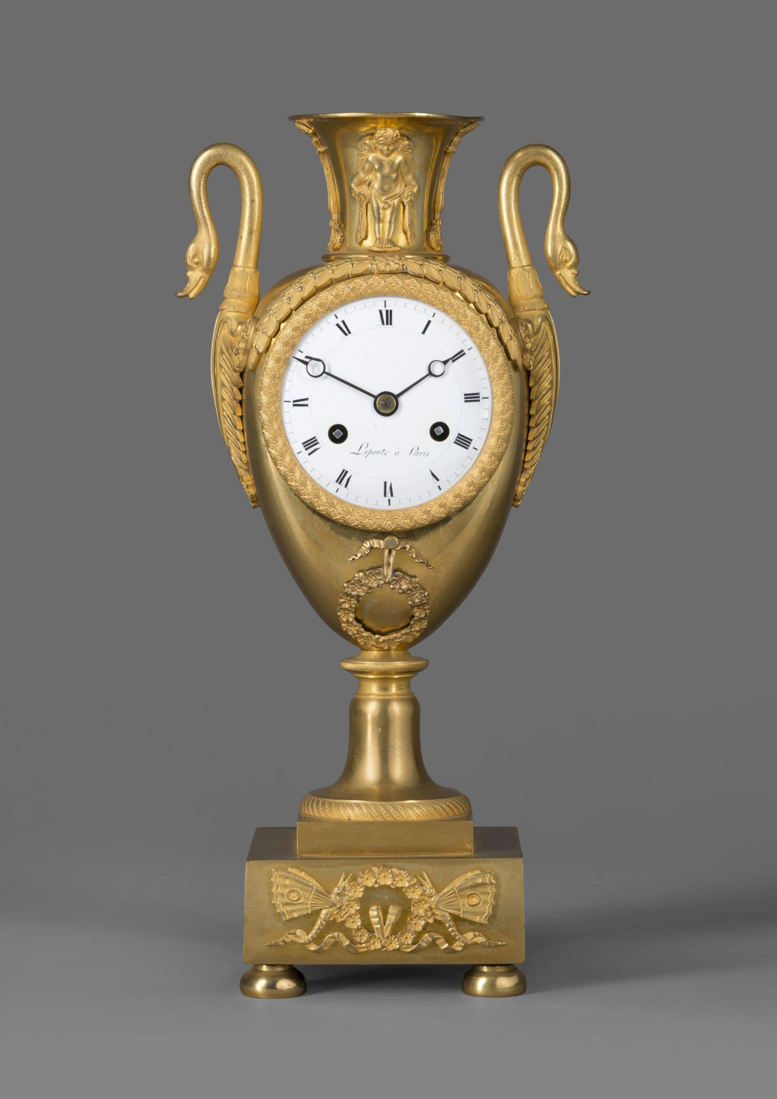A gilt bronze Empire clock in the form of a classical urn, by Maison Lepautre.

French, circa 1825.

The dial signed 'Lepaute a Paris'.

The clock has an ornate cast bezel with a 3-inch porcelain dial with Roman numerals and Breguet style