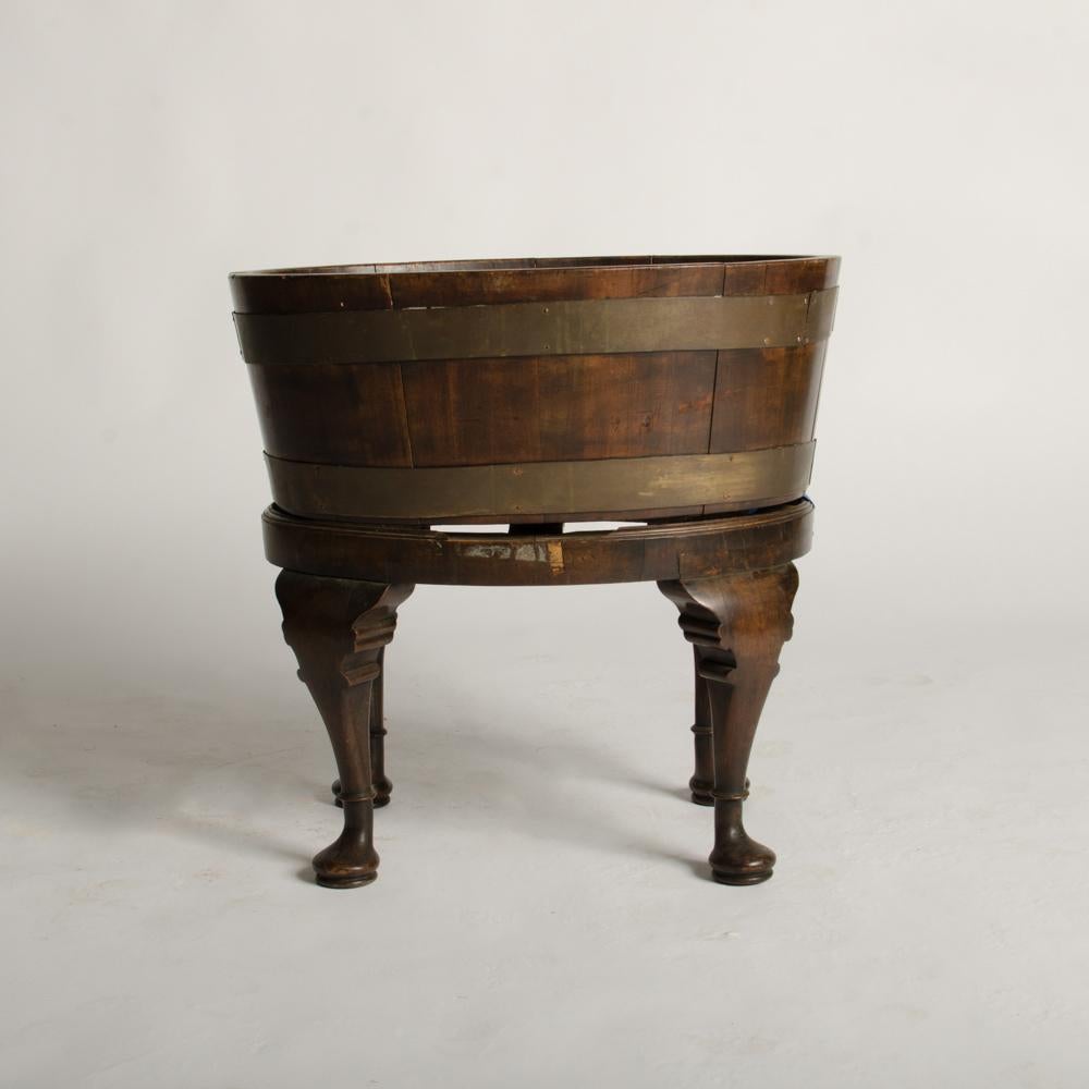 An English 1870s oval oak planter or wine cooler with brass braces and tin liner on stand.