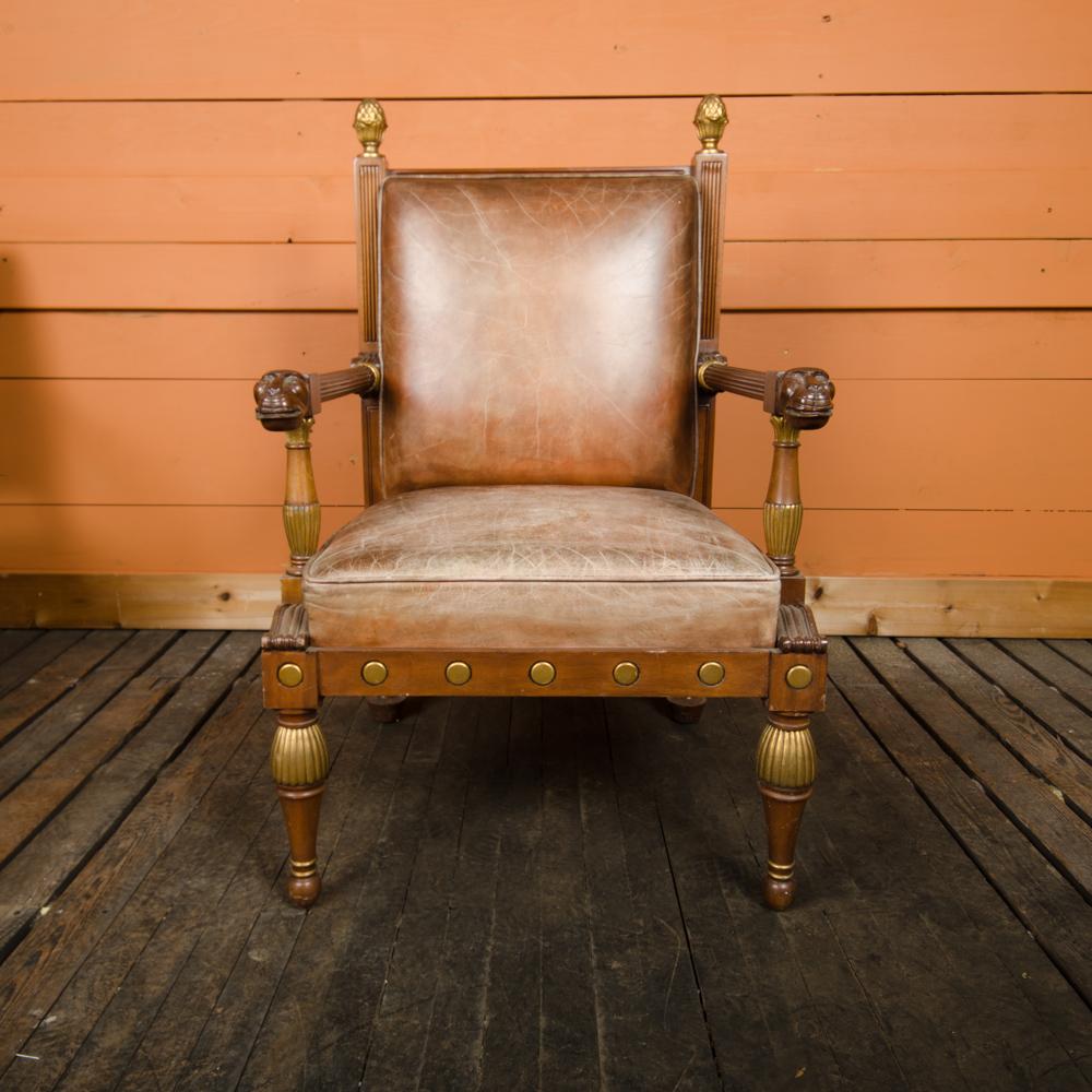 An ornamental leather and wood armchair circa 1920s. Having well-shaped and generous proportions with bronze gilt mounts. In style of George Bullock. 
 Interior W: 22