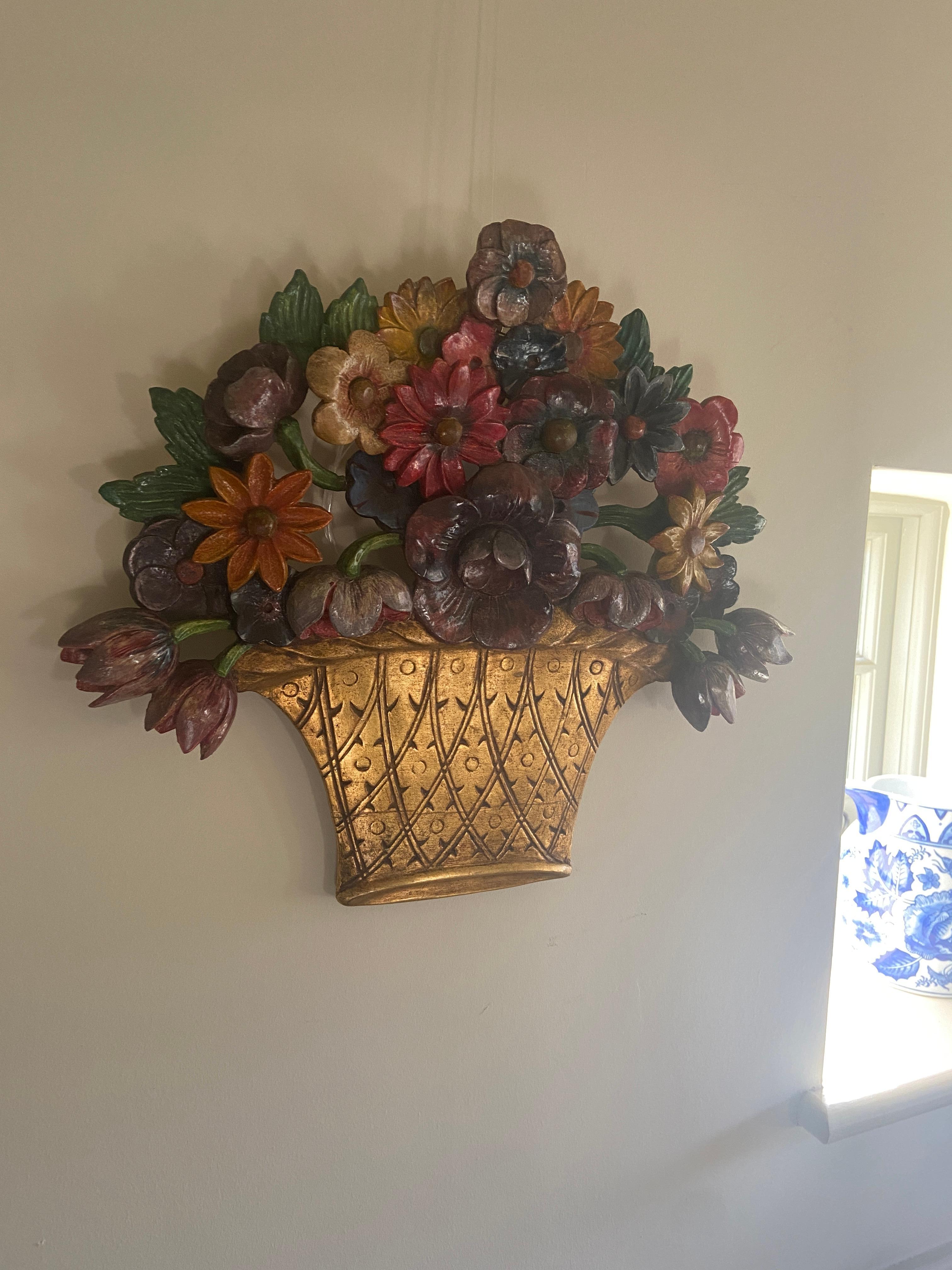 A 1930s English Art Deco floral basket  carved wood polychrome decorated wall hanging or appliqué.

This  very decorative hand carved wall hanging is fashioned as a gilded basket overflowing with with various coloured flowers and foliage. This works