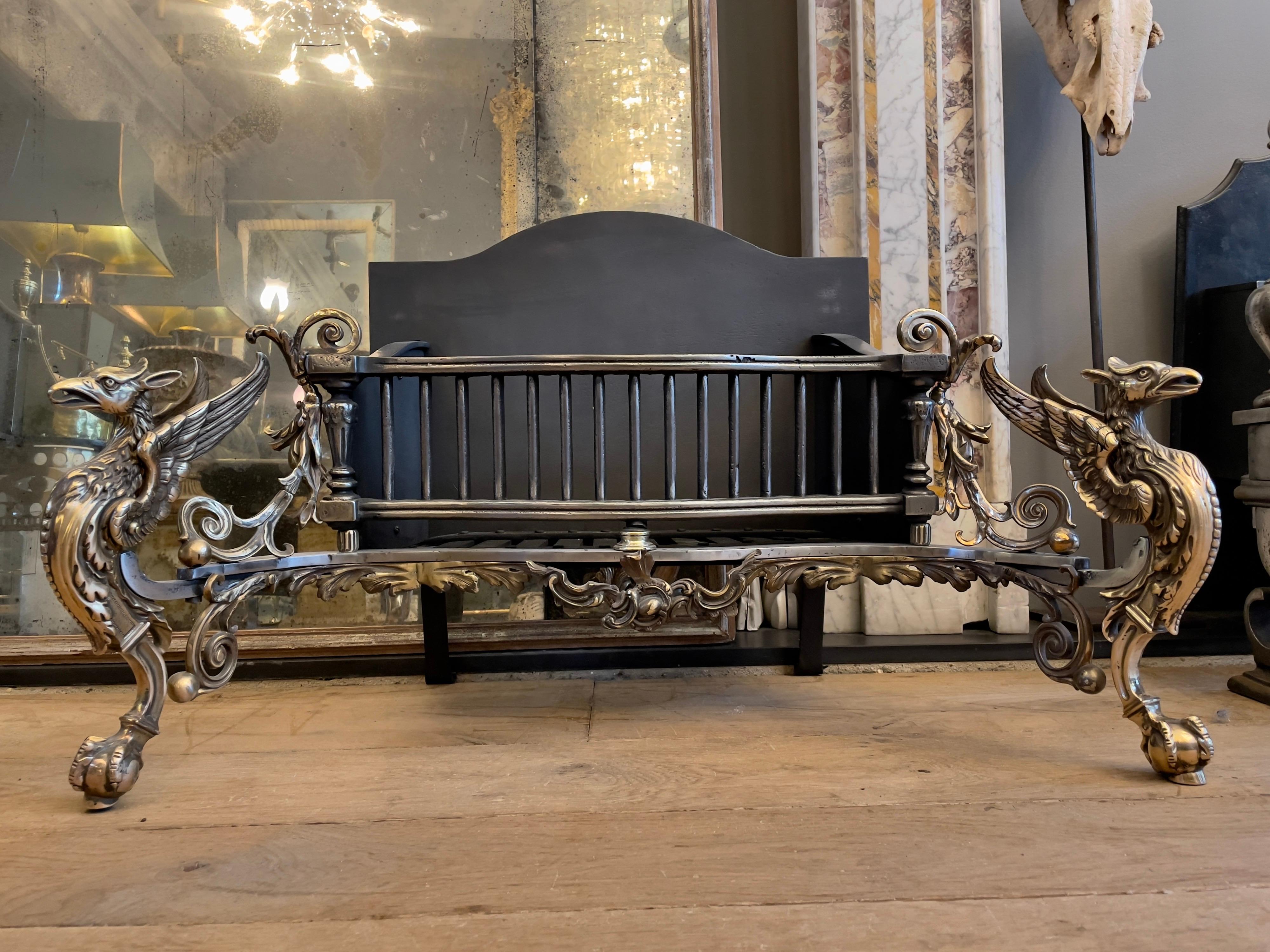 An exceptional English Rococo style Griffin fire grate in rich Gun metal and steel with shaped cast iron back. The superbly cast monopedia Griffins with ball and claw feet, spread wings and beaks as the front supports with Rococo style fret work of