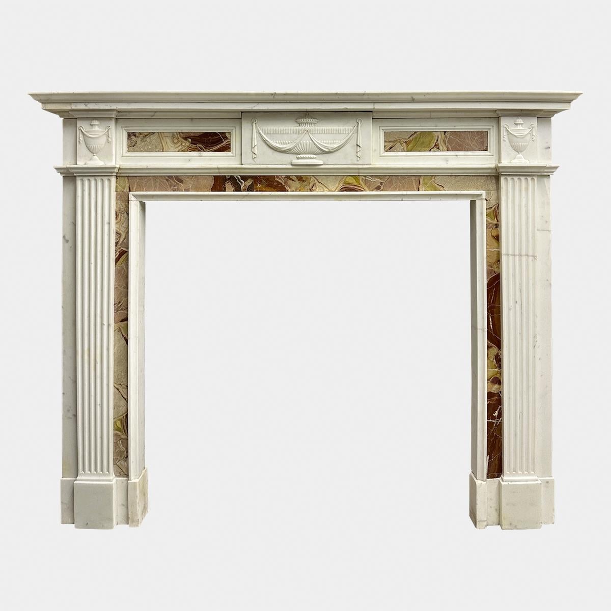 An early to mid 19th c fireplace in Statuary white and jasper marbles. The fluted pilaster jambs stood on foot blockings, with Jasper marble ingrounds, surmounted by carve corner blocks of classical urns and drapery. The frieze with centre tablet of