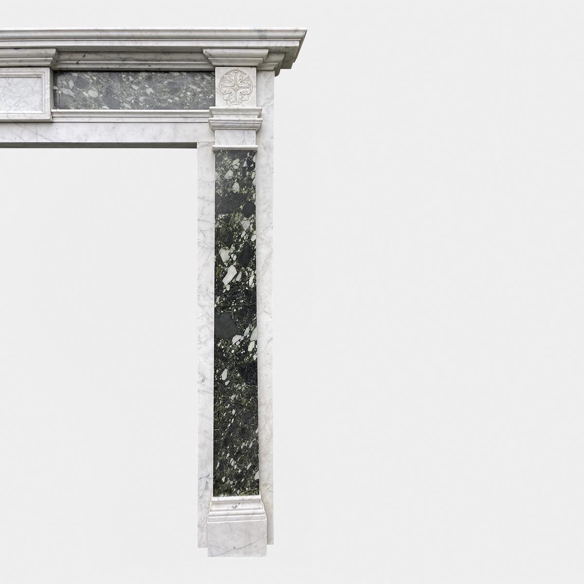 A large Georgian style antique 19th century fireplace mantel of simple yet elegant design in Antico Verde and Pencil Vein Carrara marble. The jambs in Carrara with Pilaster Antico verde supported on Carrara foot blocks and mouldings with Carrara