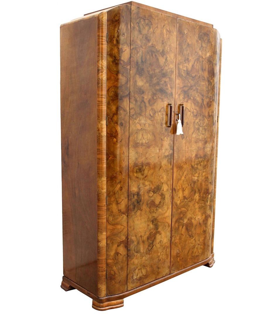This is an extremely stylish English Art Deco heavily figured Walnut two-door wardrobe, dating to the 1930's with all original fixtures and fittings. Not only does this wardrobe look the part but it's extremely functional too having a very generous