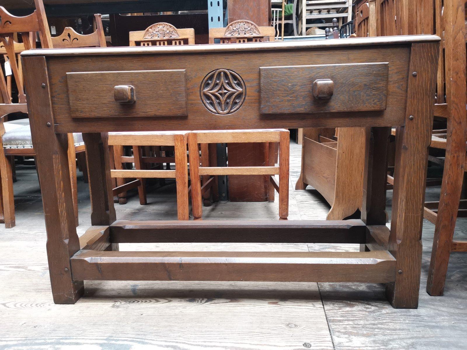 Heals. In the style of.
An English Arts & Crafts chunky oak hall or side table with a blue inset marble top, stylized carved rosette to the center flanked by a pair of drawers with square oak handles and fine dovetails, all stood on chunky legs