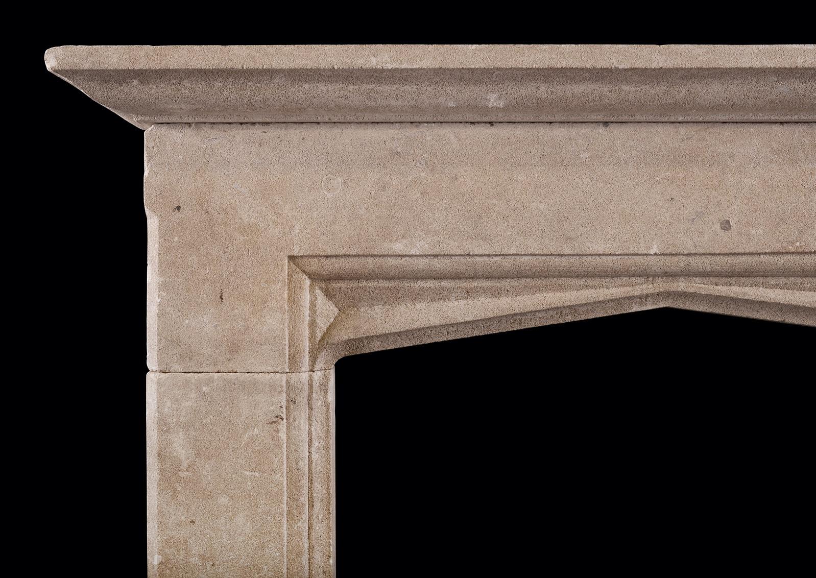 An English Bath stone fireplace in the Gothic manner. The flat jambs with inner moulding, surmounted by arched frieze with carved spandrels. Moulded shelf above. Circa 1900.  

Shelf Width:	1498 mm      	59