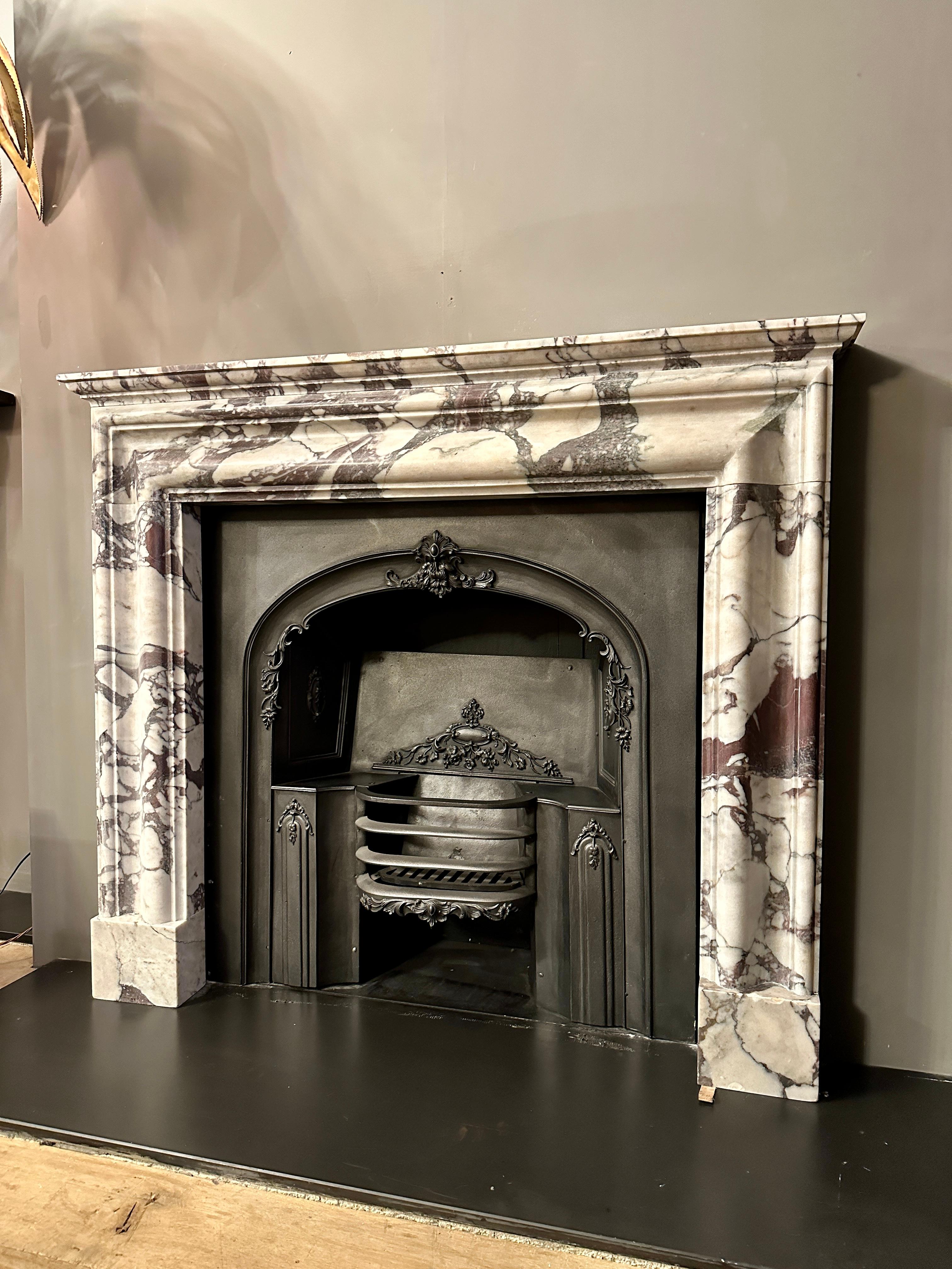 A well proportioned English fireplace in quality Breche marble. The variegated marble with soft tones and strong violets. The frame with a deep moulded  sweep and stepped outer edge, supported on square footblocks with a stepped mantle