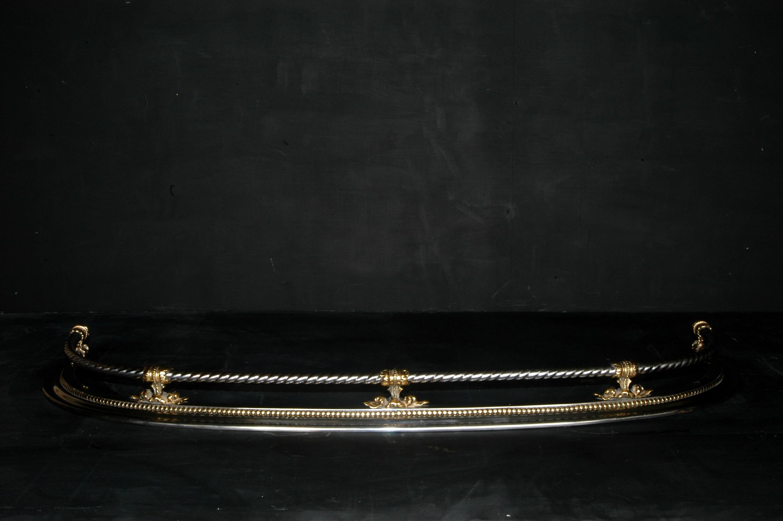 19th century steel and bronze fender with curving returns and rope twist bars and beading.

External Width:	1420 mm      	55 ⅞