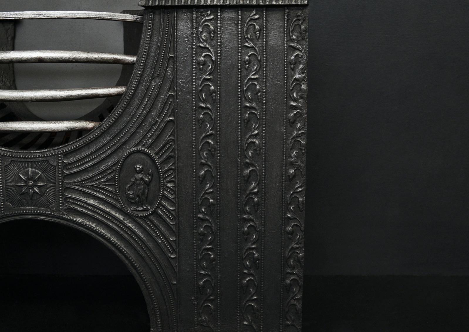 An hour glass shaped cast iron hob grate. The decoratively cast front panel featuring star paterae display to centre, flanked by classical figures and scrolled foliage. Polished front bars to burning area. English, 19th century.


Width At