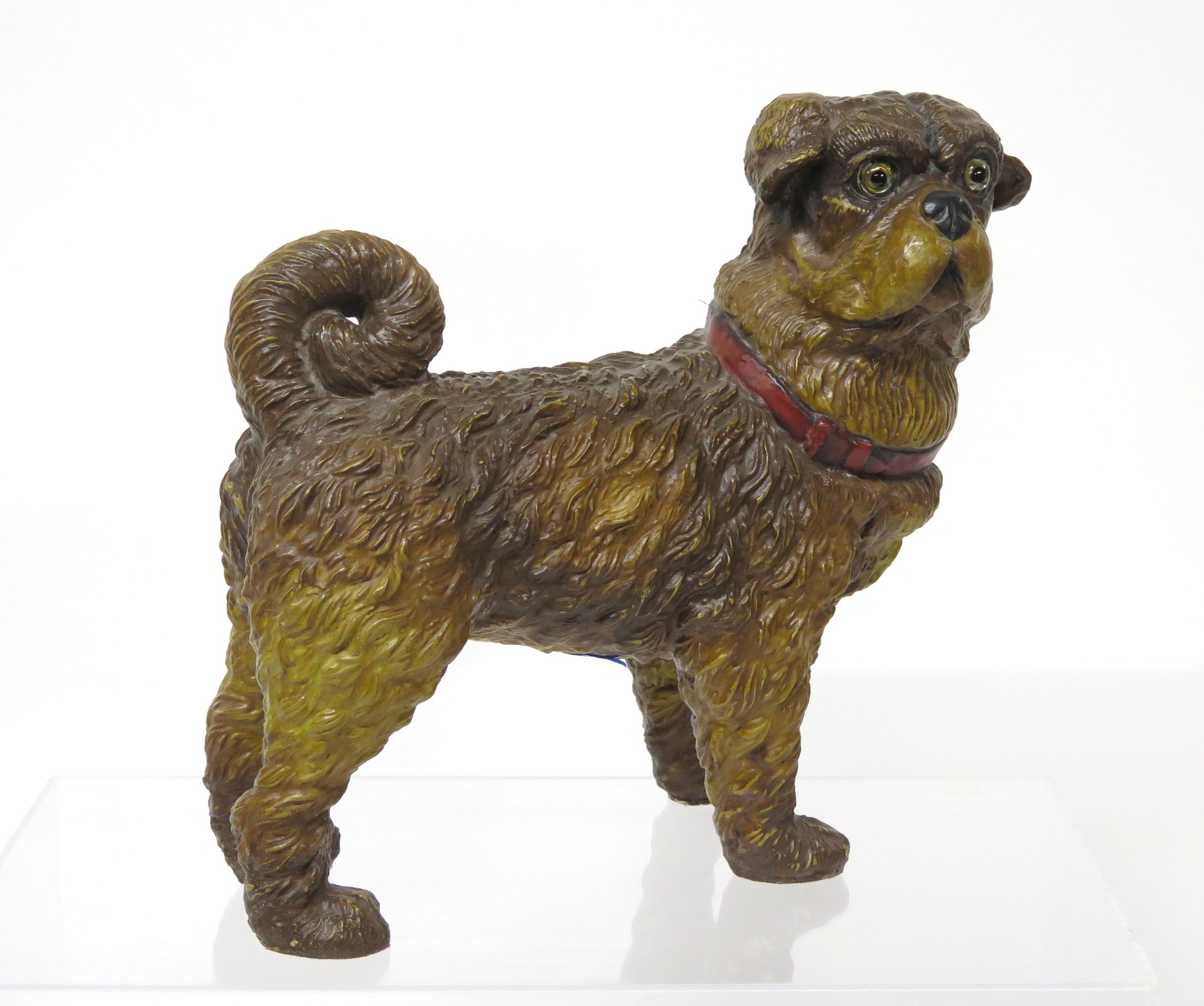 Eine englische Hundeskulptur aus dem 20. Jahrhundert, mit Glasaugen und rotem Halsband. Diese Hundeskulptur wurde um die Jahrhundertmitte in England hergestellt und zeigt einen Mops, der stolz und fest auf seinen vier Pfoten steht und eine wachsame