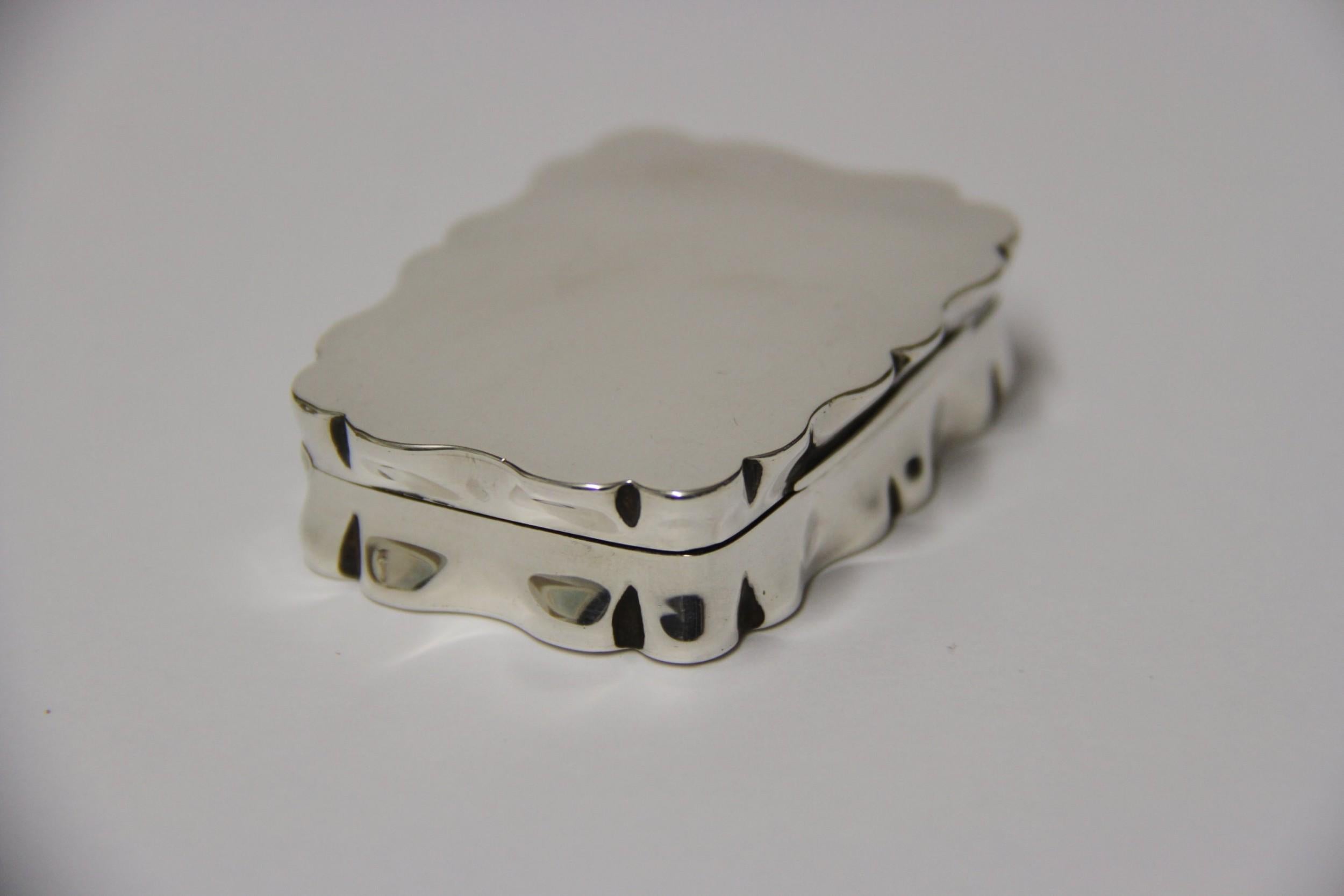 A silver snuff box made in the Edwardian period. This good quality box is rectangular with serpentine edges. The lid is hinged across the complete back and fits well. The box is in good condition with minor age related marks. Hall marked,