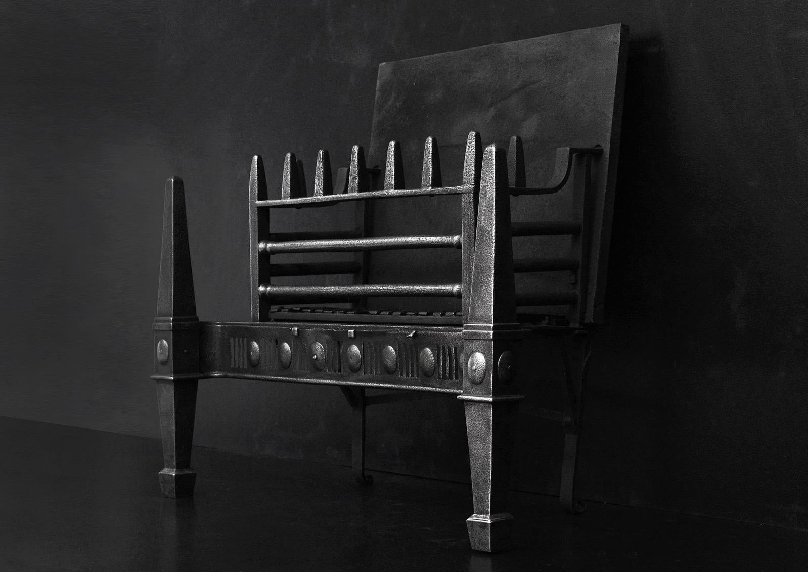 A 19th century cast iron firegrate. The legs tapering legs surmounted by obelisk finials, the fluted fret with oval paterae throughout. The burning area with plain front bars and matching obelisk uprights above. English.

Width At Front:	840 mm     