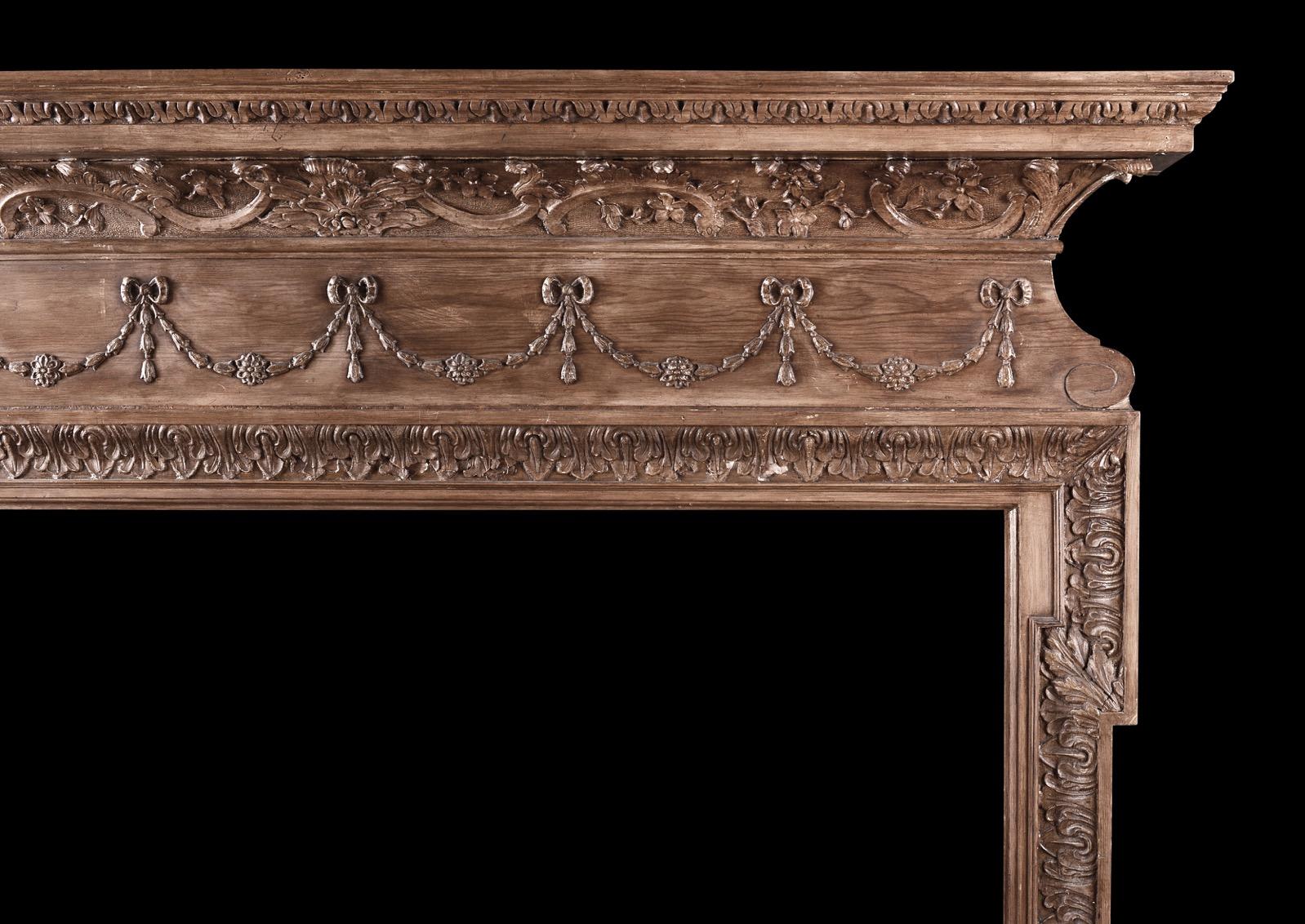 An English fireplace in the Georgian manner. The jambs carved with acanthus leaf work surmounted by frieze featuring swags, ties and belldrops. The shelf with oak leaf to bed mould and acanthus leaves above. 19th century. 

Shelf Width:	1646 mm   | 
