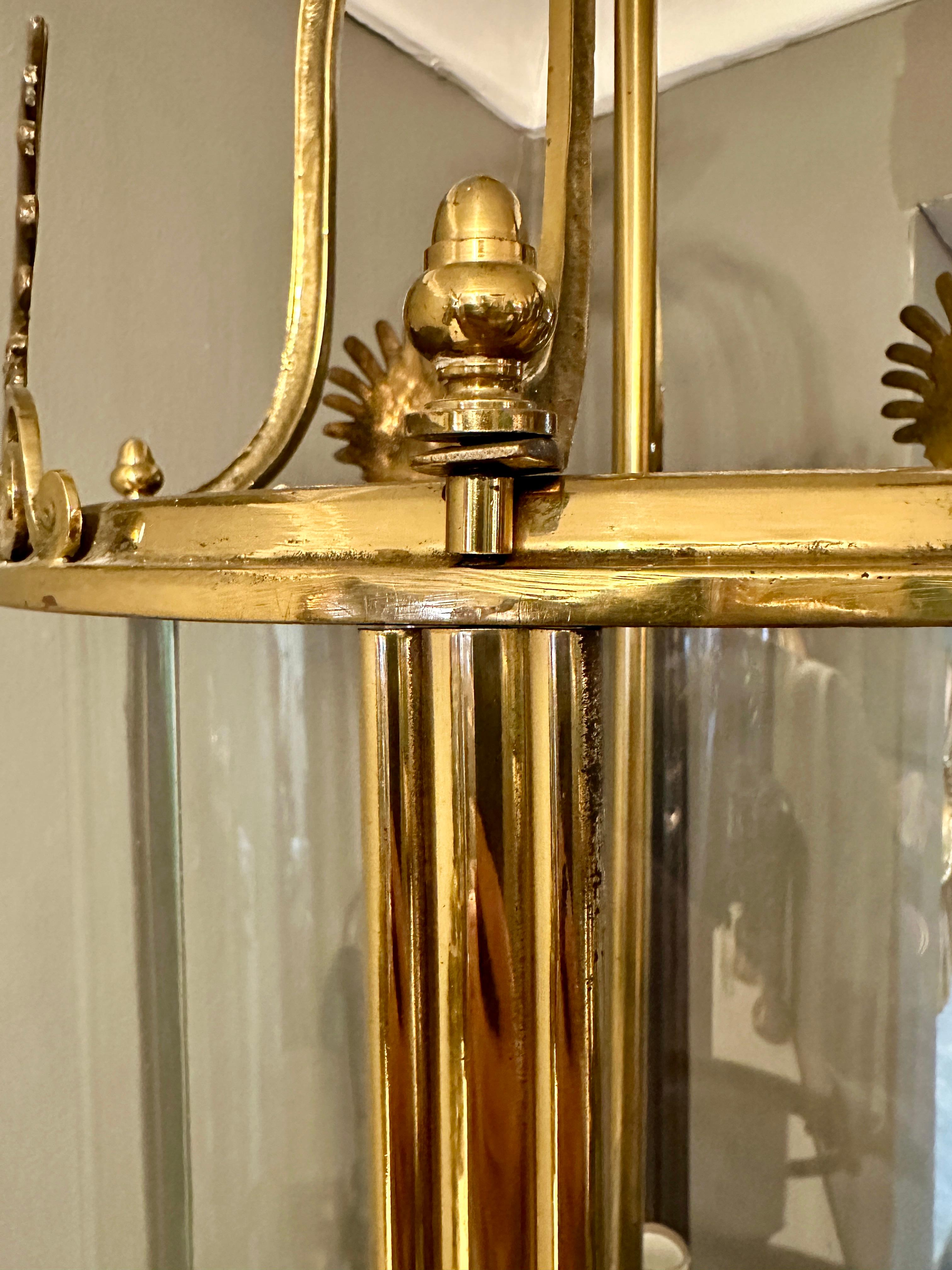 Eine große zylindrische Laterne mit 4 gebogenen Glasscheiben, gerippten Stützen und Endstücken oben und unten. Innen vierarmiger Ast, geschwungene Galeriearme und vier Anthemion-Motive über jeder Tafel. Eine englische Laterne von guter Qualität aus