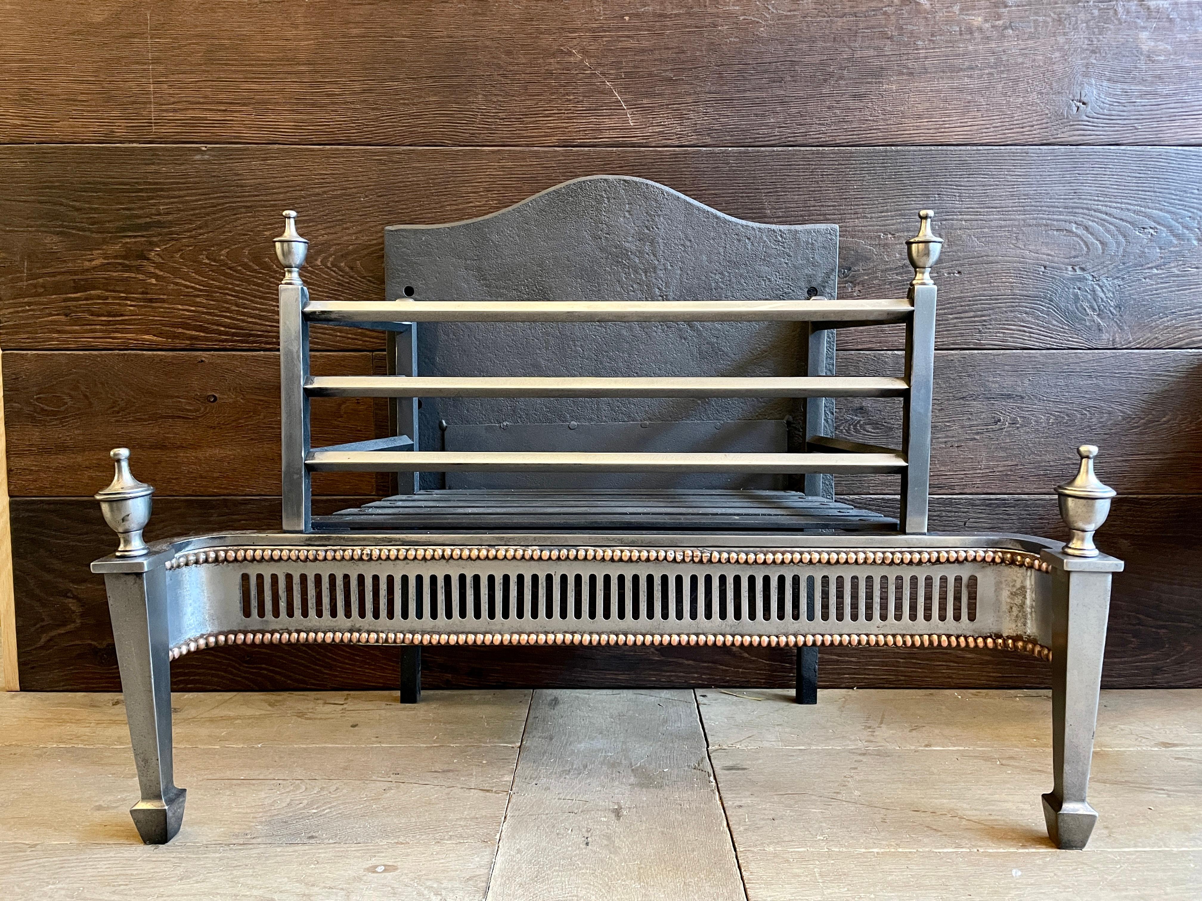 An unusual Steel George II style fire grate or Dog grate. The cut steel fret edged with Gun metal beading, tapering front legs with shaped feet surmounted by finials. The railed burning area open on 3 sides with a shaped cast iron back.
Front