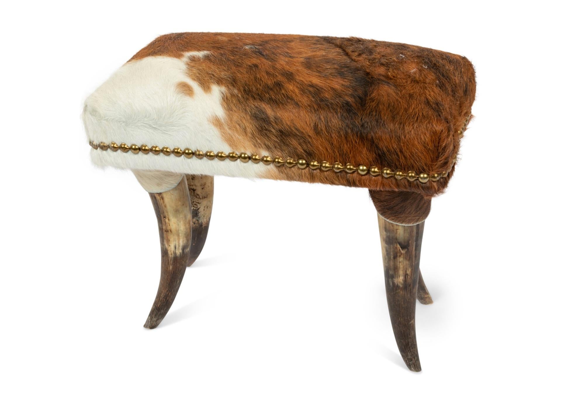 An English Horn Chair and Ottoman Covered In Cowhide, Brass Head Trim.
20th Century
adorned with spurs.
Height 43 x width 29 x depth 35 inches.  Can save shipping charges is shipping within or close to Denver Colorado.