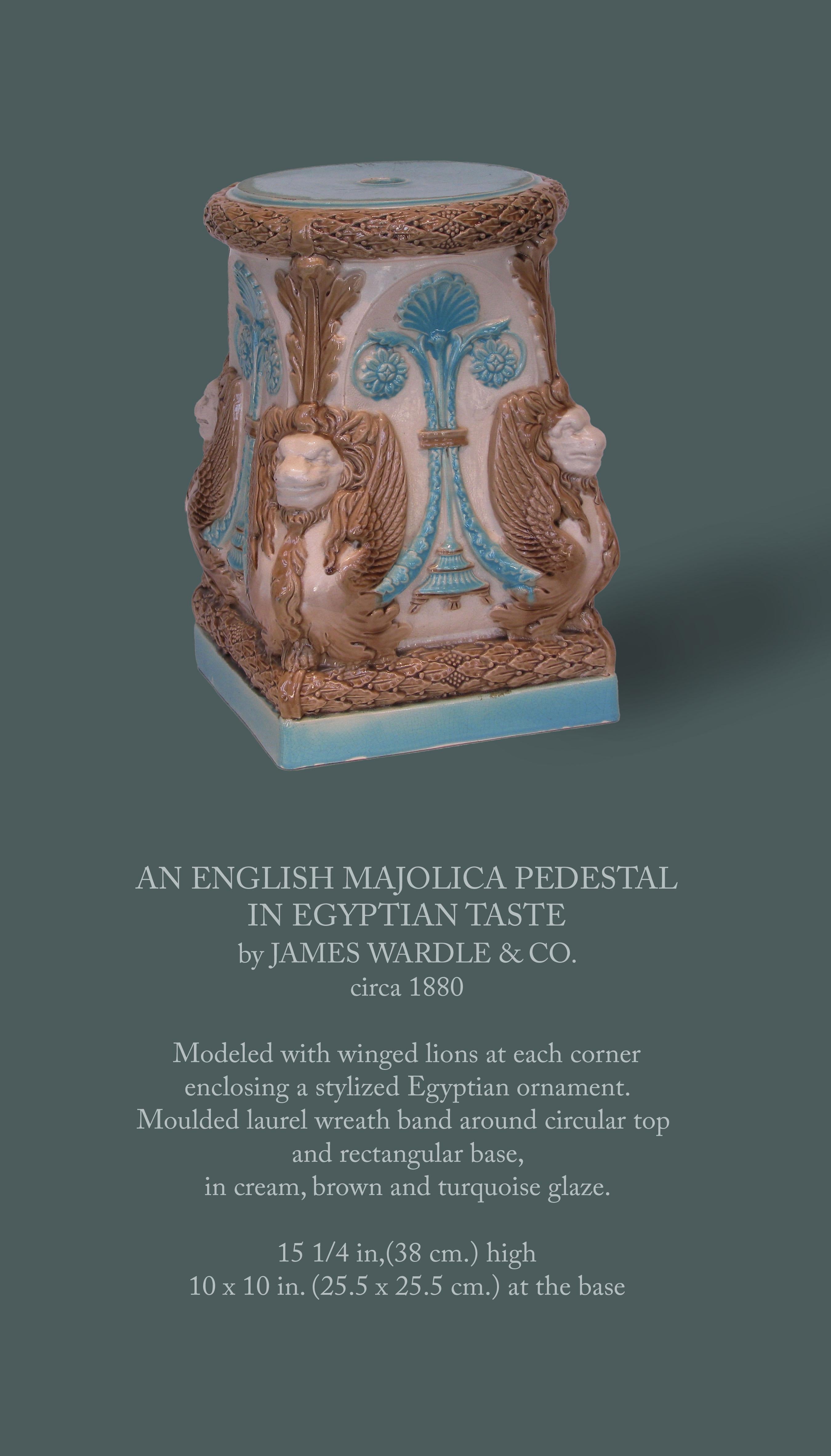 AN ENGLISH MAJOLICA PEDESTAL
IN EGYPTIAN TASTE
by JAMES WARDLE & CO.
Circa 1880

Modeled with winged lions at each corner
enclosing a stylized Egyptian ornament.
Moulded laurel wreath band around circular top and rectangular base,
in cream, brown