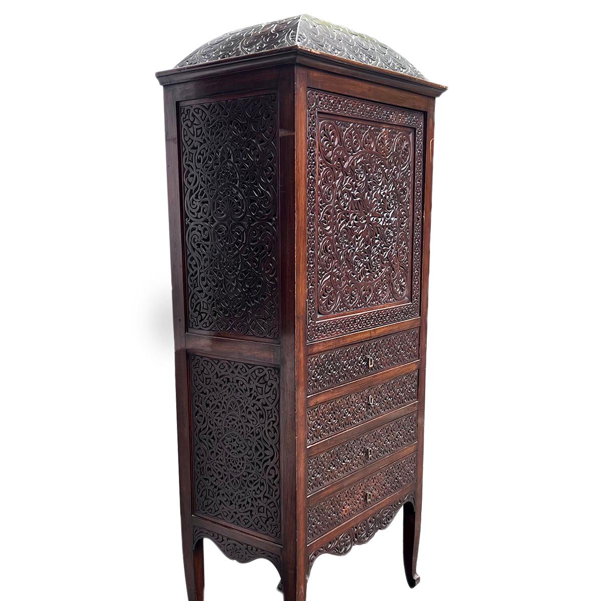 A circa 1920s English carved wood cabinet with arabesque motif on front and sides.

Measurements:
Height:70.75