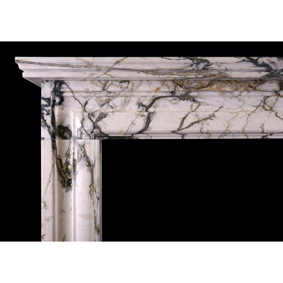 An English moulded bolection fireplace in Calacatta Verde marble. A scaled down version of a chimneypiece originally housed in the Officer's mess at Chelsea Barracks, London. Can be made to any size, in various materials. N.B. May be subject to an