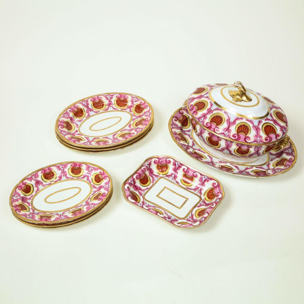 Chacune est peinte avec audace d'une bordure de coquillages rouge fer et de feuillage rose, comprenant une soupière, un couvercle et un support, un légumier rectangulaire et six plateaux ovales de deux tailles différentes, certains avec des chiffres