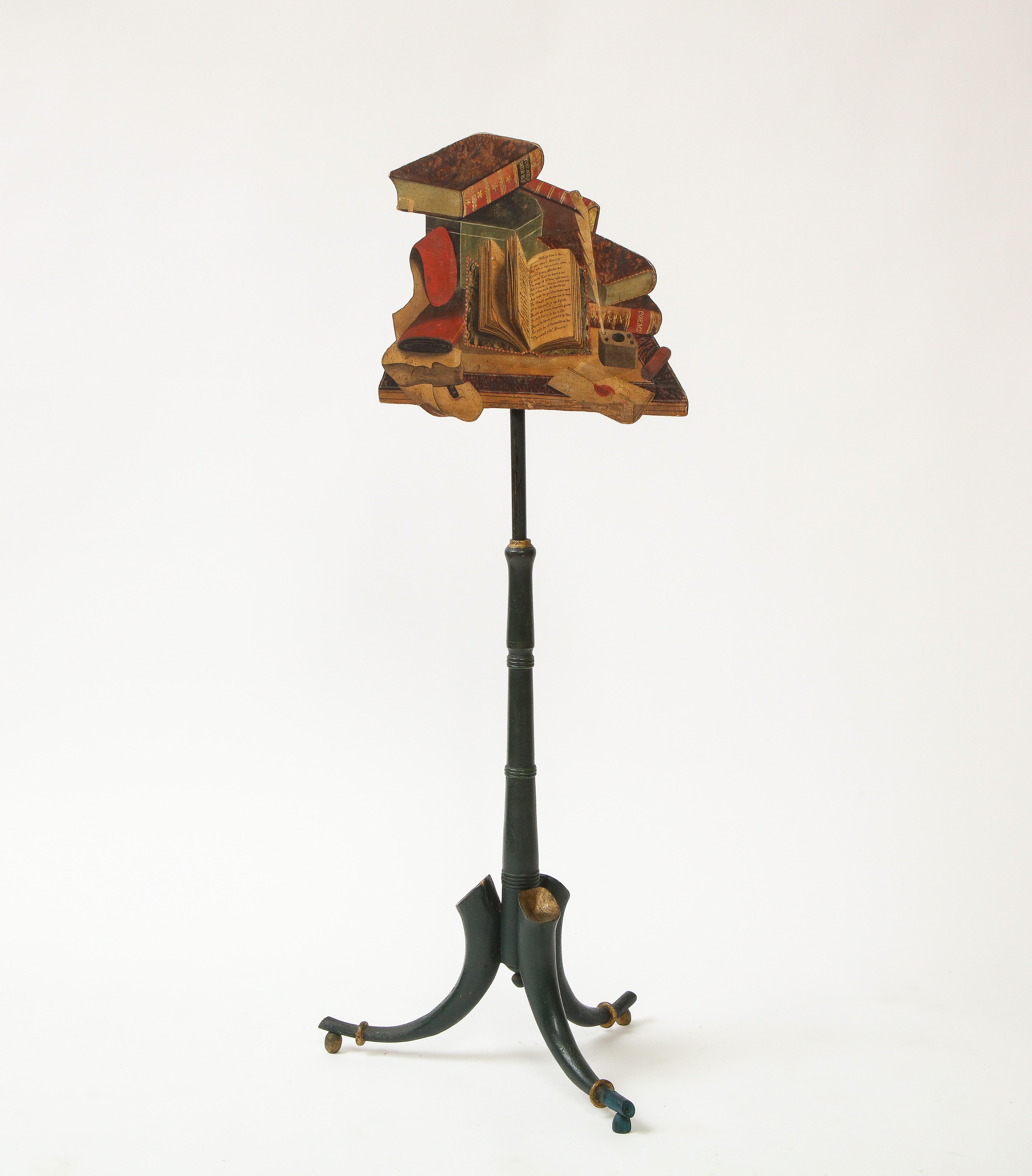 Featuring a trompe l'oeil screen depicting antique books of poetry, an inkwell with plume, wax-sealed letters and papers. Mounted on a dark-teal painted metal stand, ending in horn-shaped feet on raised gilt balls.