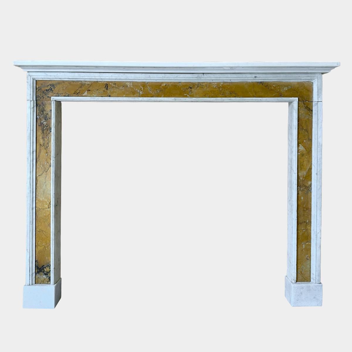 An architectural style Statuary white and Siena marble fireplace in the Queen Anne manner. The simple yet appealing contrast between the two marbles making a very smart fireplace. Stood on white foot blocks with panels of Siena within moulded white