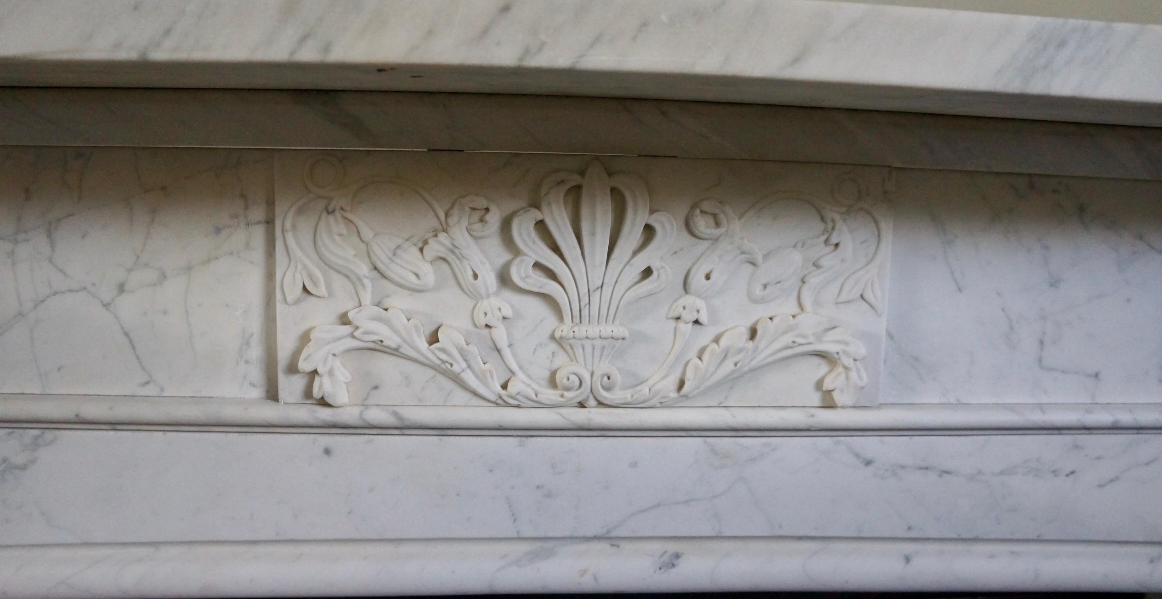 An Imposing and quality Regency period surround in Pencil Vein Carrara Marble. The jambs with tapering fielded panels, surmounted by Anthemion  carved corner blocks. The moulded ingrounds supporting a lightly arched opening. The frieze with centre