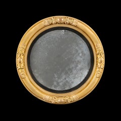 An English Regency Giltwood Convex Mirror with Carved Eagle Cresting