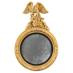 An English Regency Giltwood Convex Mirror with Carved Eagle Cresting