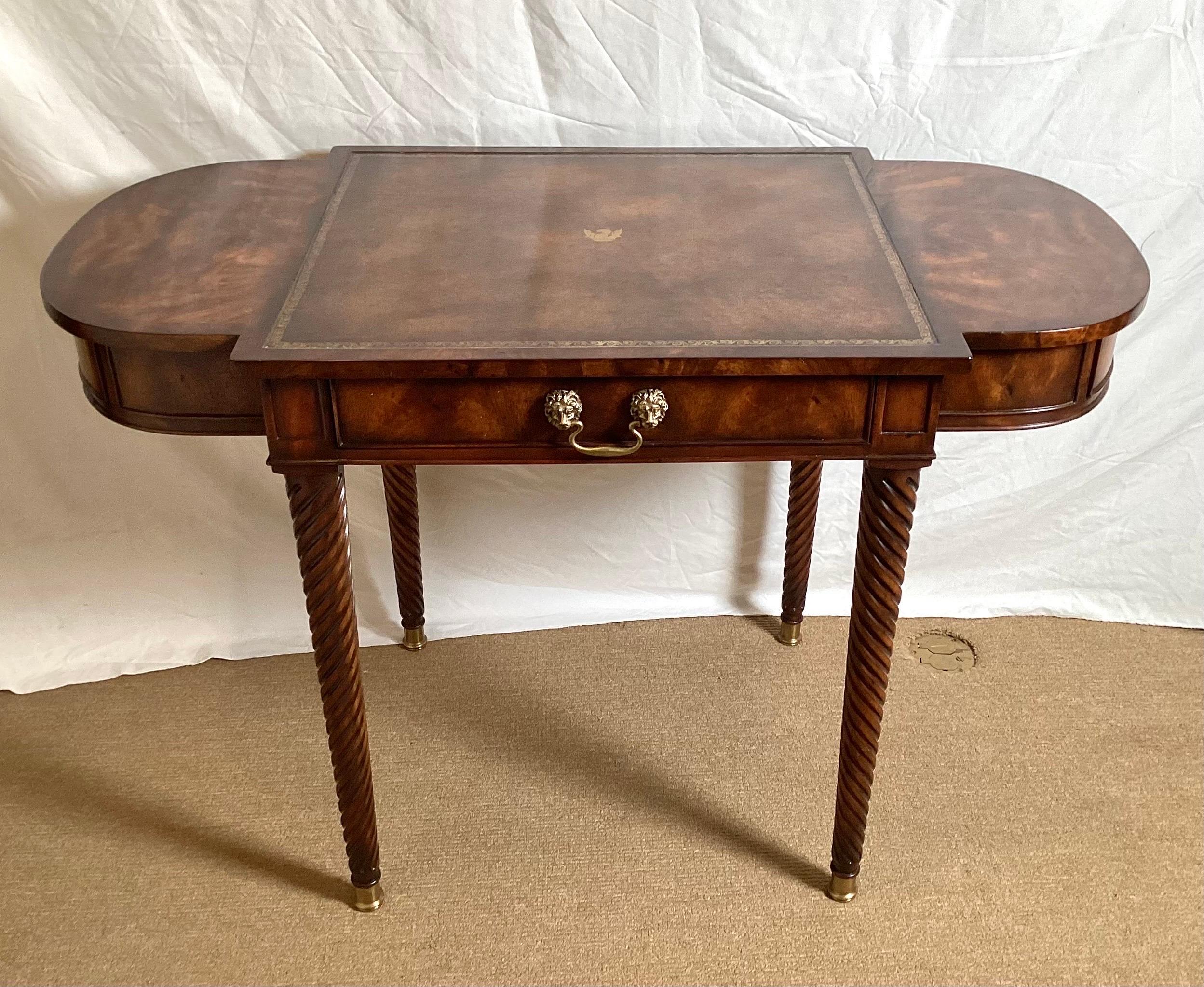 Elegant Theodore Alexander leather and walnut diminutive writing desk. The central drawer with two D shaped drawers one on each side, the top with a Tabaco tooled leather top, resting on four spiral turned legs.
