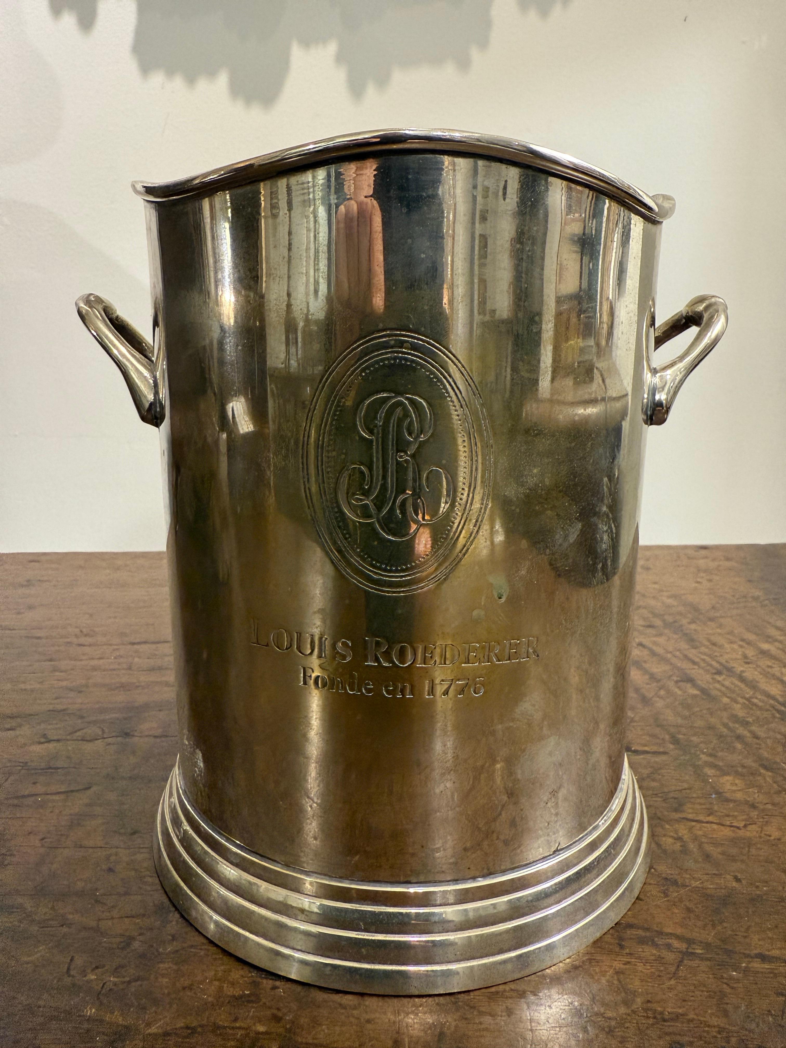An English Silverplate Champagne Cooler, Early 20th Century

Provenance: Private Australian Collection.

Description:
The stepped circular base to cylindrical body with rising curved handle on either side conforming to the elegant curvilinear rim. 