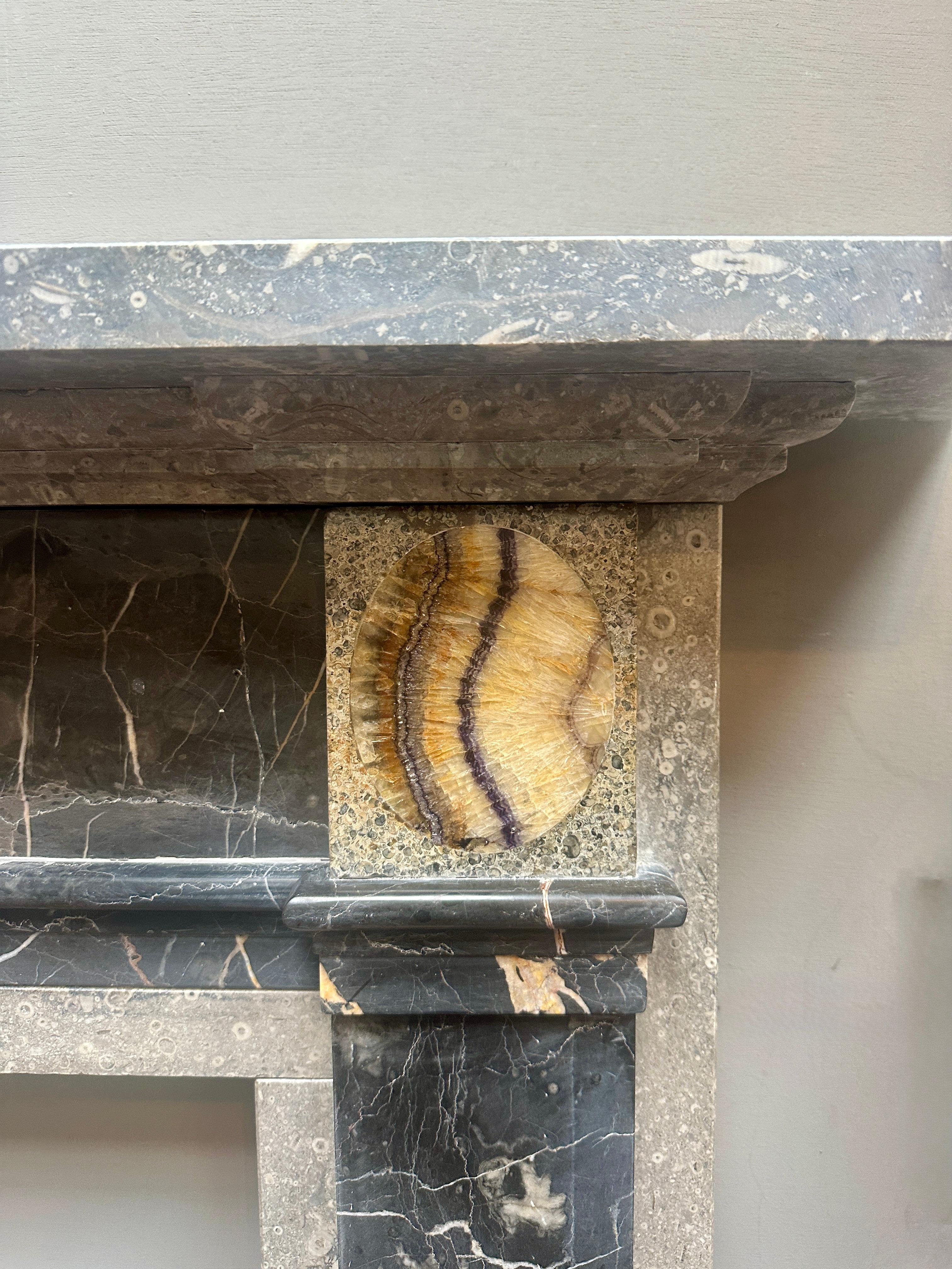 An unusual George III style chimneypiece executed in 6 different English marbles. 

The pilaster jambs of Derbyshire fossil marble with Ashburton marble panels to front and foot blocks. Purbeck marble corner blocks inlaid with Blue John marble. The