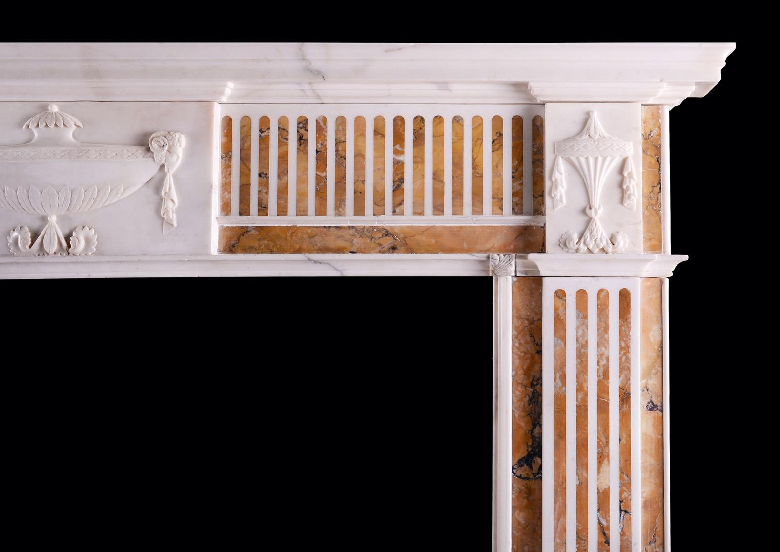 A good quality English Statuary marble fireplace with Italian Siena marble inlay. The fluted jambs surmounted by carved end blockings with classical finials. The frieze with matching fluting, with urn to centre block carved with rams heads, leaves