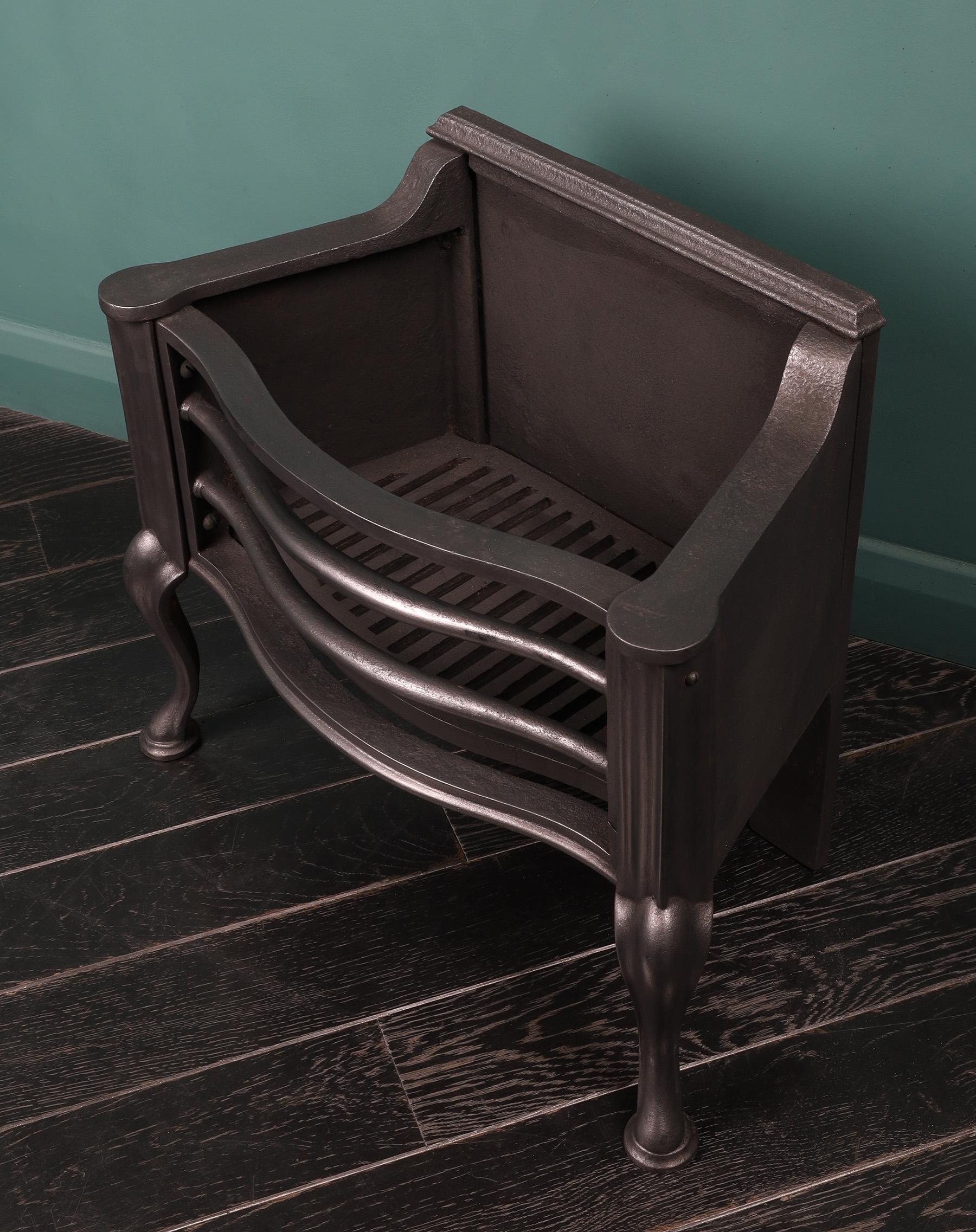 An English steel fire basket by Thomas Elsley of London in the Queen Anne manner. The basket with shaped fire bars, cabriole legs and scrolled fret. The cast-iron fire back with roller wheels. Finish in black. Restored.
Width at rear: 15 1/2