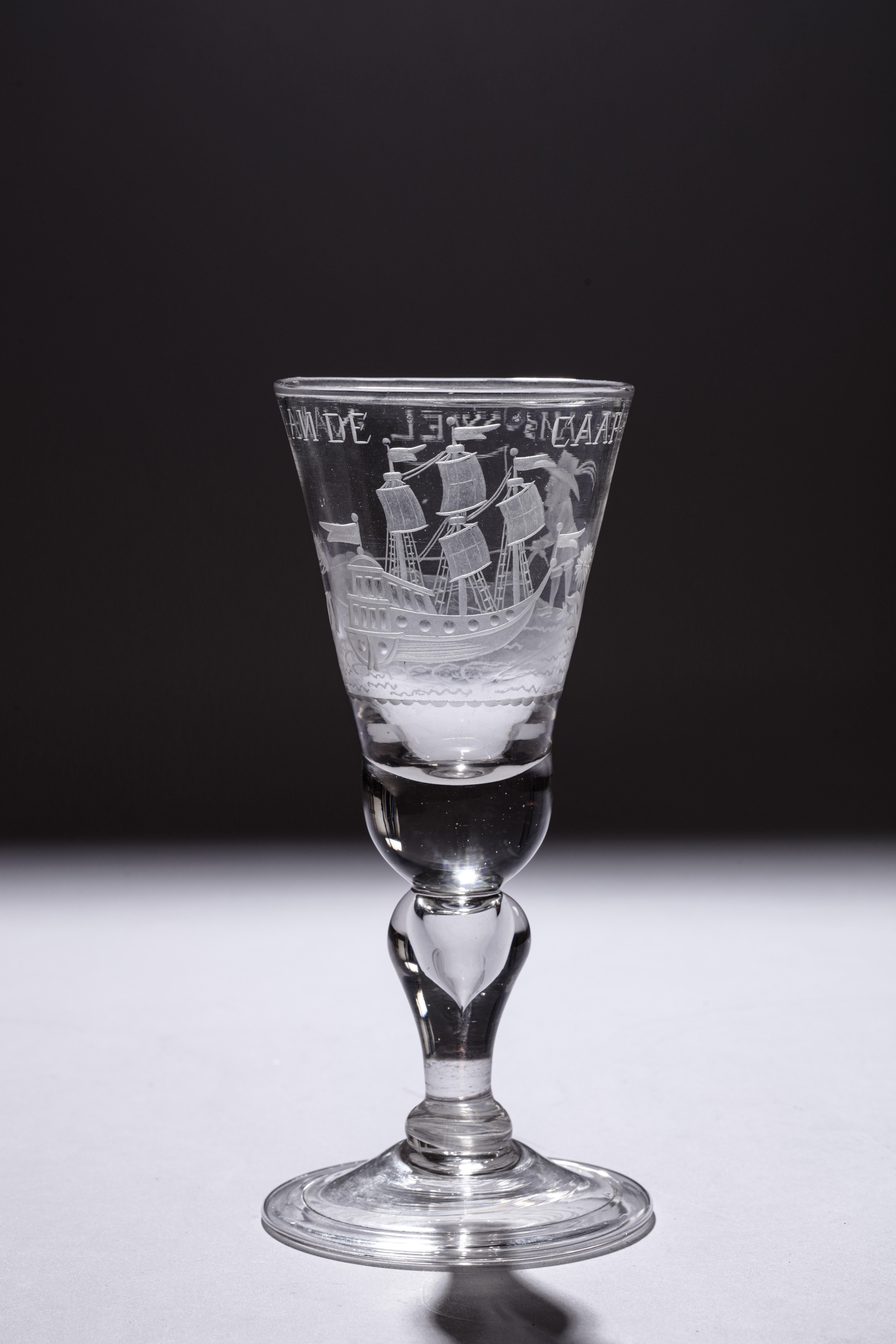 A commemorating glass with an engraving of a farmer ploughing, an East Indiaman and a text reading:
Het Lan’s Wel Varen An De Caap (the country’s prosperity at the Cape of Good Hope)

German glass with Dutch wheel-engraving, first half of the