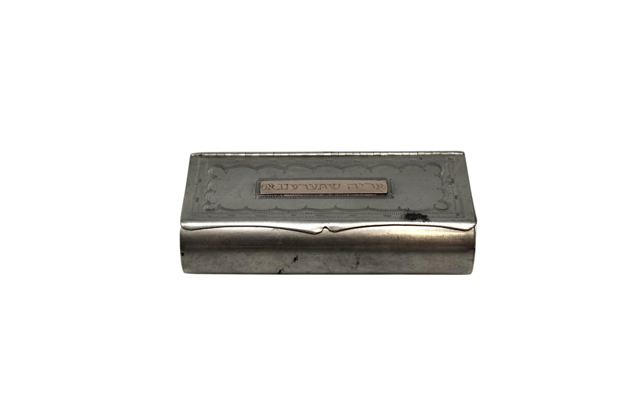 This charming engraved pewter snuff box, dating to circa 1900, is a beautifully preserved example of everyday Judaica—a personal object once carried and cherished, now elevated by its artistry and cultural resonance.

Cast in a rectangular form with