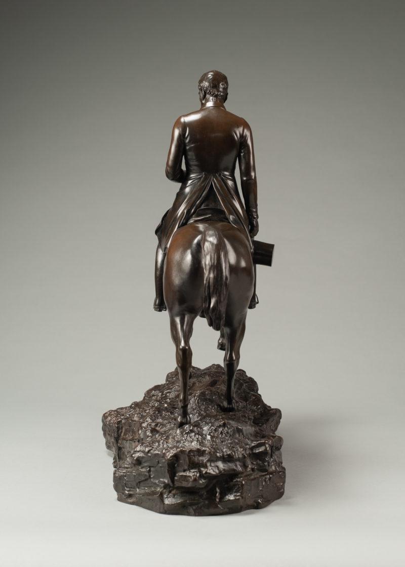 This bronze statuette shows Arthur Wellesley, Duke of Wellington riding his warhorse Copenhagen.  He is dressed in civilian clothes with the reins in one hand and his top hat in the other.  The engraving on the bottom of the horse’s underbelly