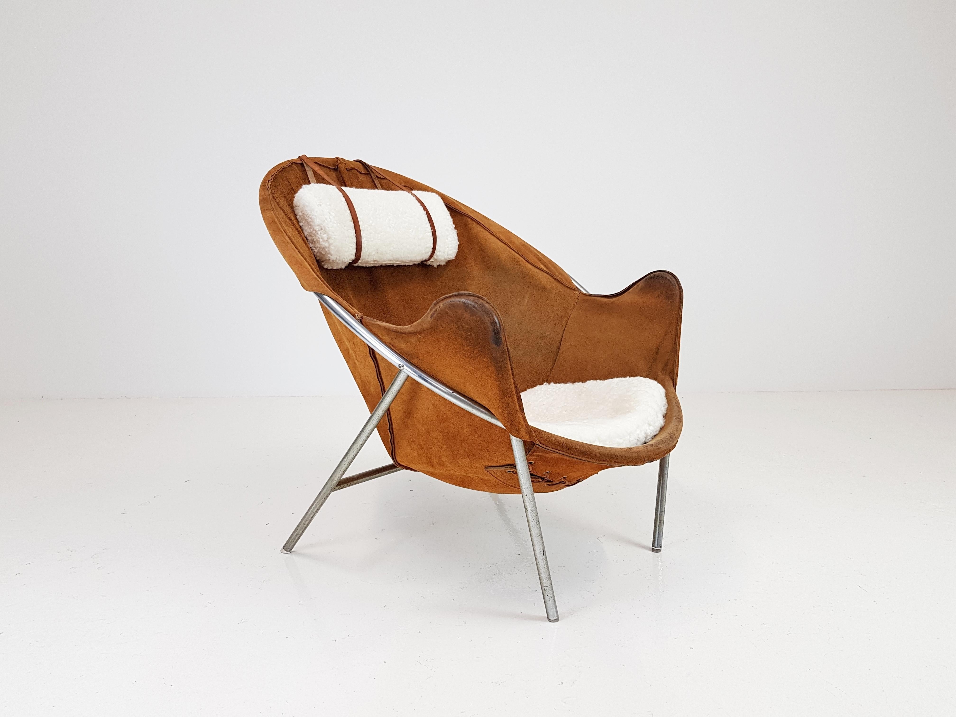 An Erik Ole Jørgensen lounge chair for Olaf Black, in Cognac suede, Denmark, 1953. 

The lounge chair features a suede sling over a tubular frame with a sheepskin seat pad, a sheepskin headrest cushion which is counterbalanced by leather and wood