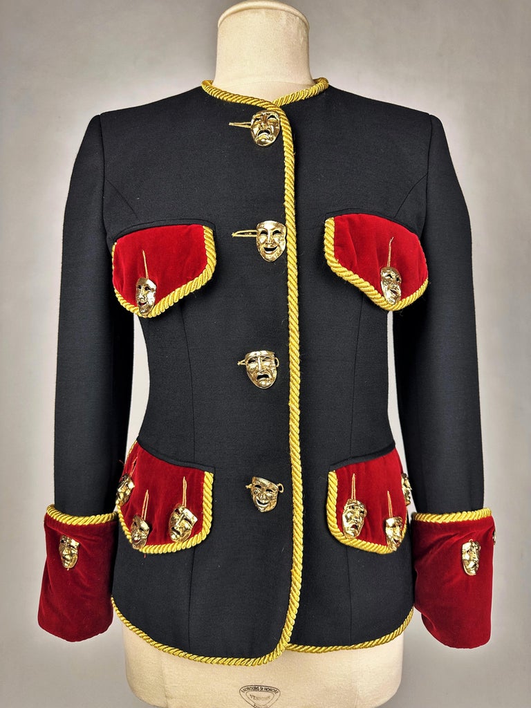 Circa 1990-1992

Italy

Iconic evening jacket from the most creative period of Mr. Franco Moschino who passed away in 1994. Fitted jacket, collarless and long sleeves with musketeer cuffs. Complete with 18 golden brass buttons with masks taken from