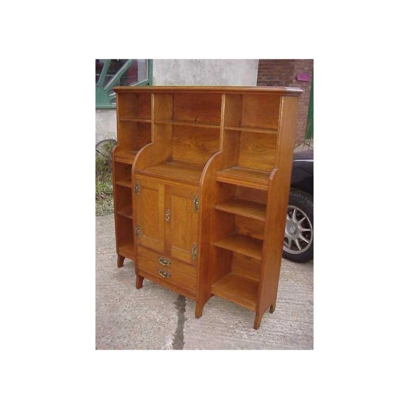 Aparador/librería de roble Arts and Crafts de excelente calidad, de Maple and Co, con magníficos tiradores y bisagras de latón floreado estilizados, diferentes del anterior, pero totalmente originales, ya que se podían elegir los tiradores y
