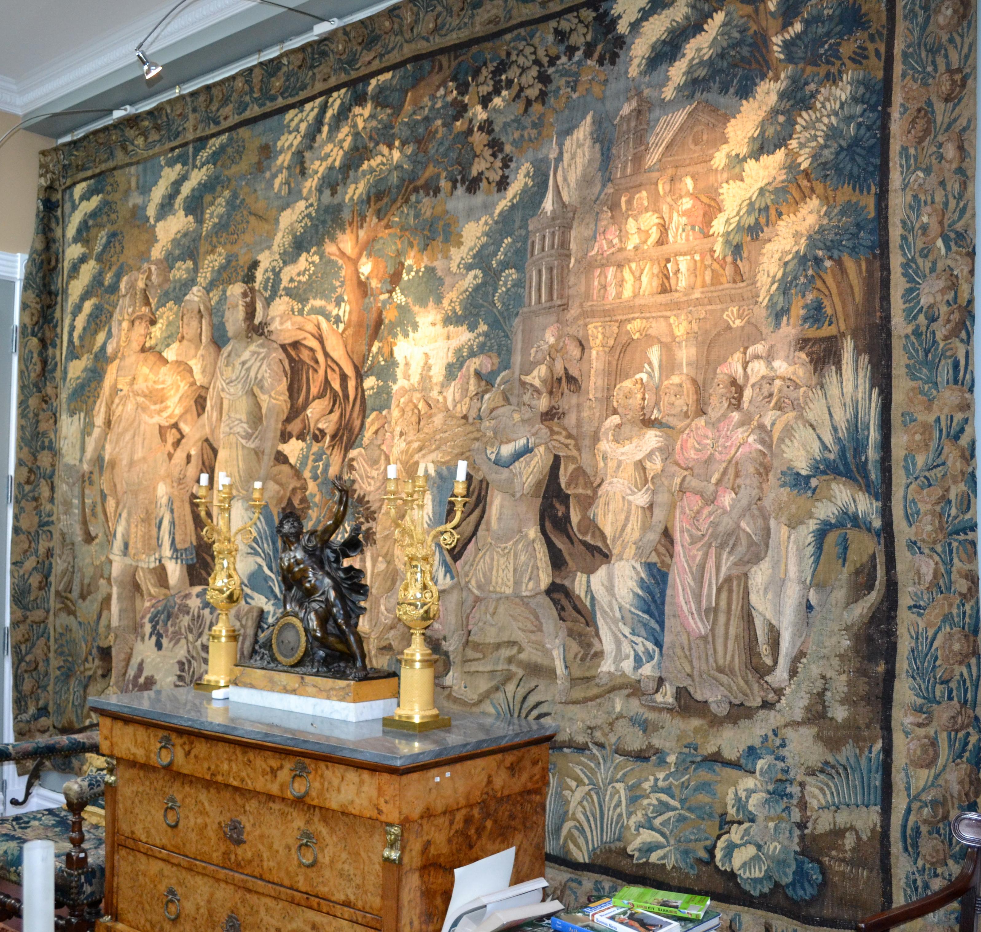 A spectacular flemish 17 century combined verdure and mythological handwoven wool tapestry in a simple palette of beige, green, brown and blue, framed with a complete floral border and its original protective burlap backing .Combining romanticism,