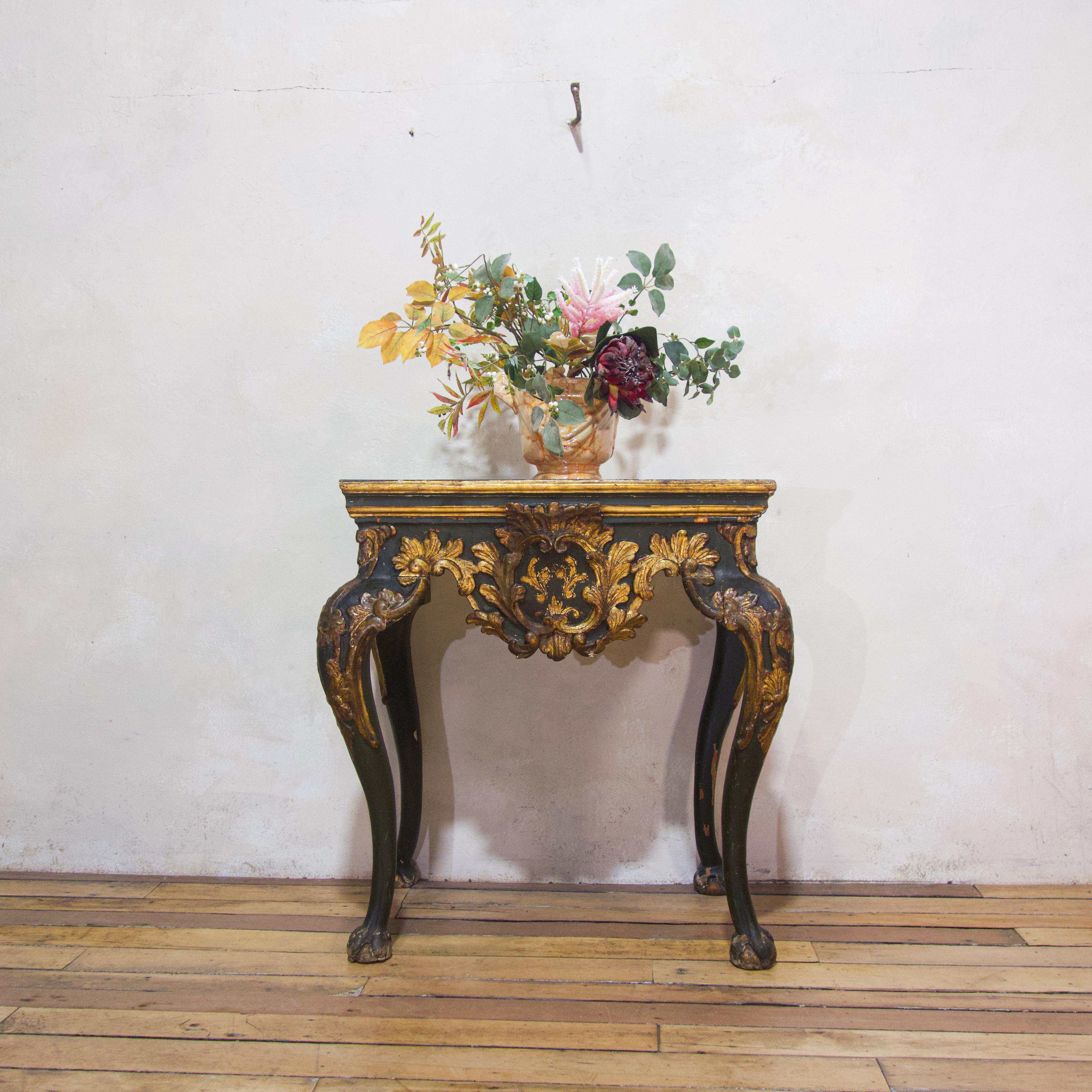 An exceptional early 18th century Italian Baroque console table. Demonstrating its original rich green paint with gilded detailing throughout. Displaying an inset rouge marble top above a shaped apron with scrolling acanthus decoration. Raised on