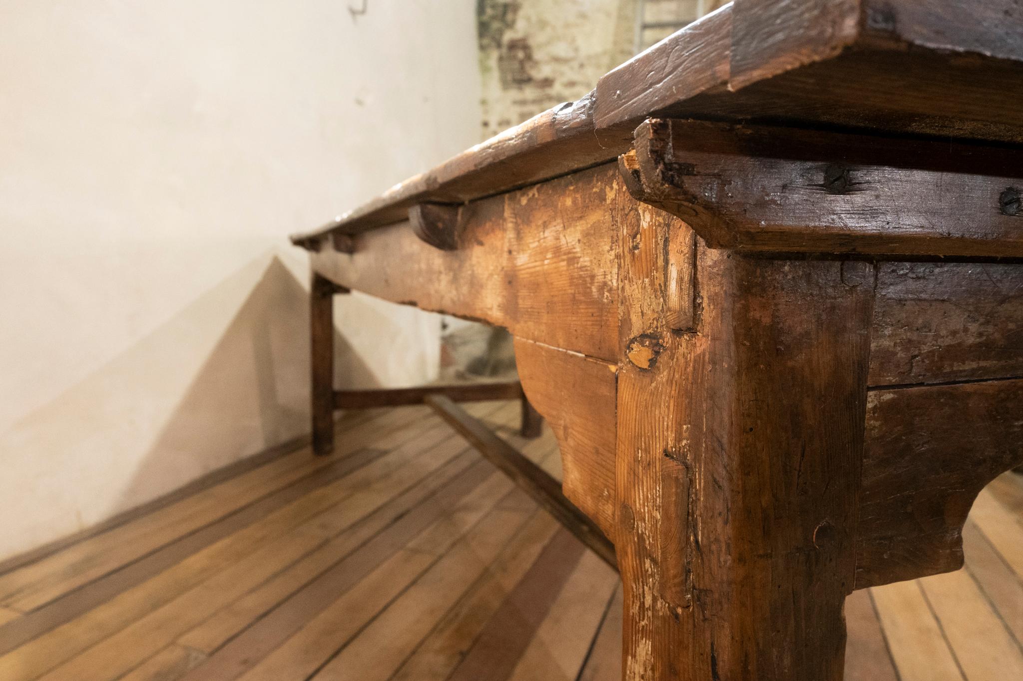 An exceptional 18th century and later French provincial farmhouse table. Raised on four chamfered legs, united by a H stretcher. Demonstrating traces of original paint to the base. Displaying a wide two plank later top, married at some point during