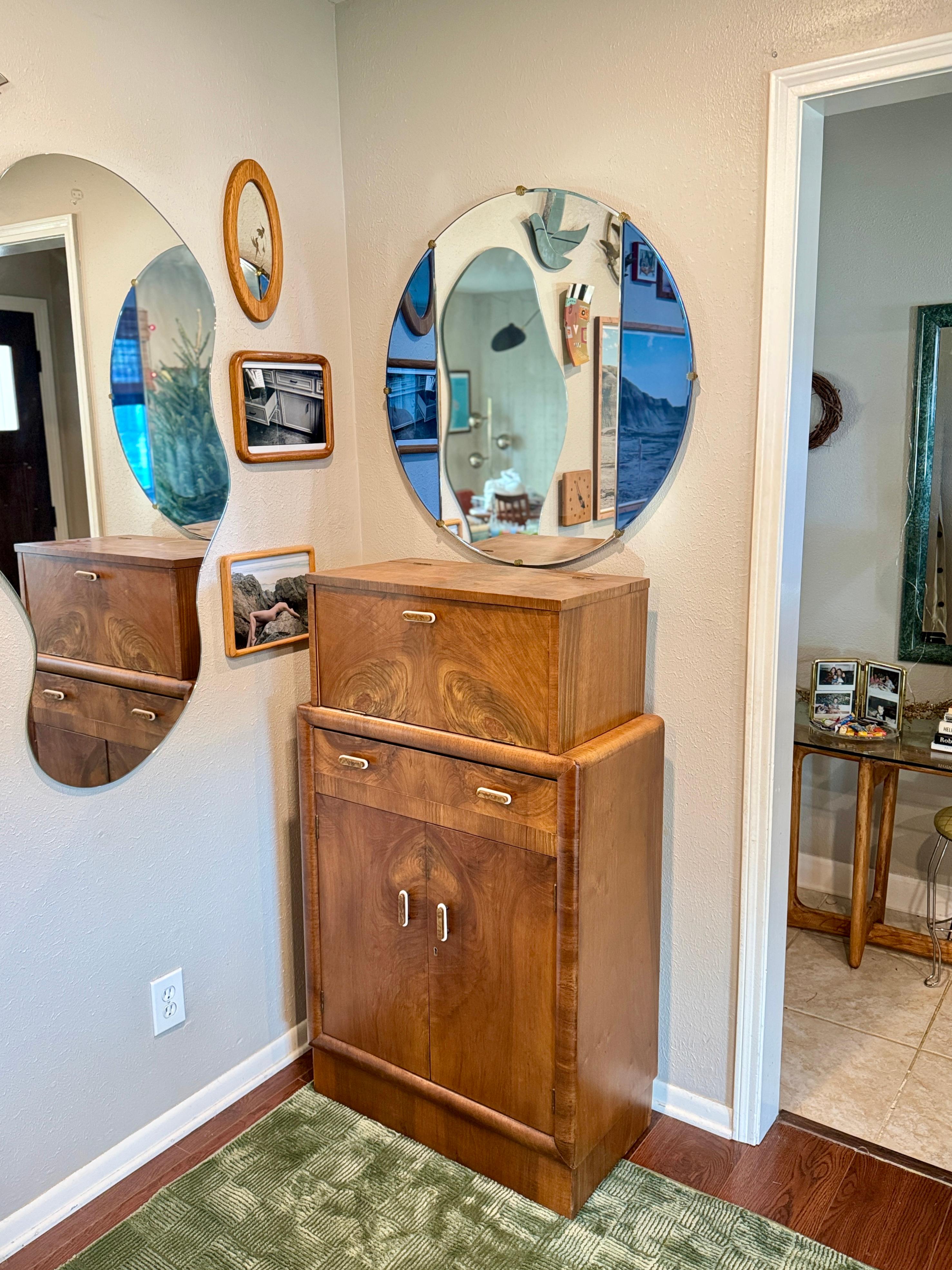 An exceptional Art Deco bar cabinet, circa 1930s. This dry bar has all the bells and whistles you want from a cocktail cabinet. The upper interior has a mirrored base and mirrored backing along with the original cocktail lemon squeezer that are so