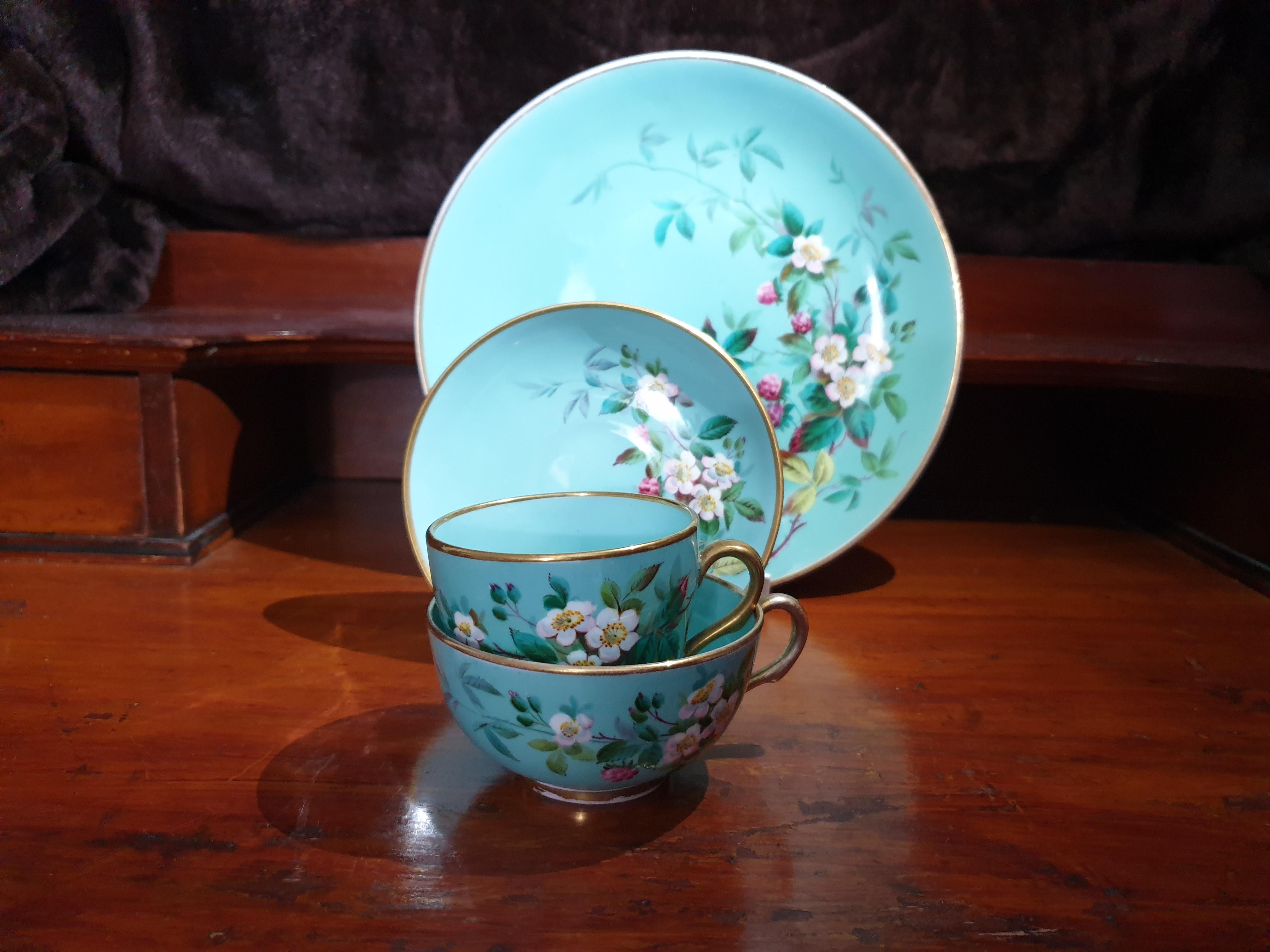 An exceptional mint coloured Floral Brown Westhead & Moore (Brownfield) Quarto which includes a tea cup, coffee cup, saucer and cake plate. Each piece is handpainted with lovely roses and fruits. Finished with 24k Gold gilt rims and handles in